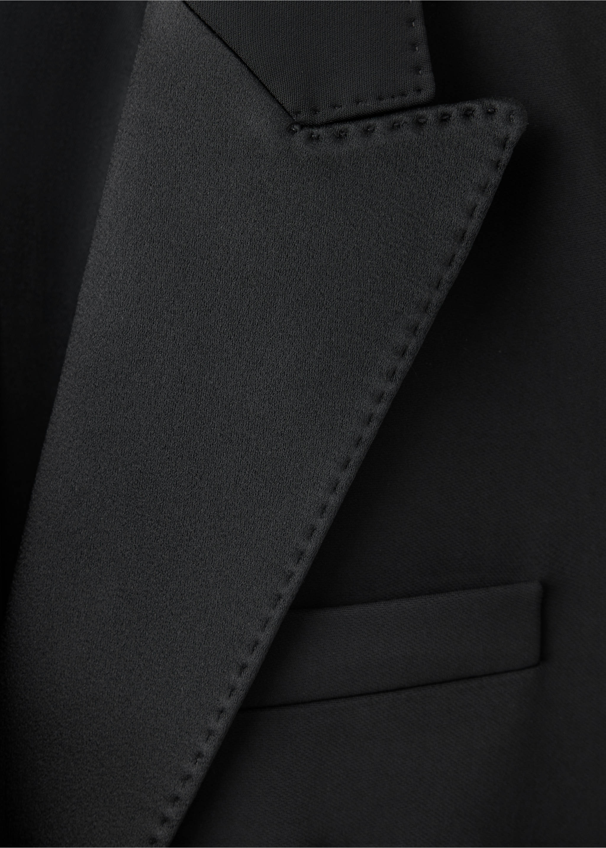 Close-up of a black blazer showing the satin peak lapel and topstitching detail., Black. Ref: 47061470-00.