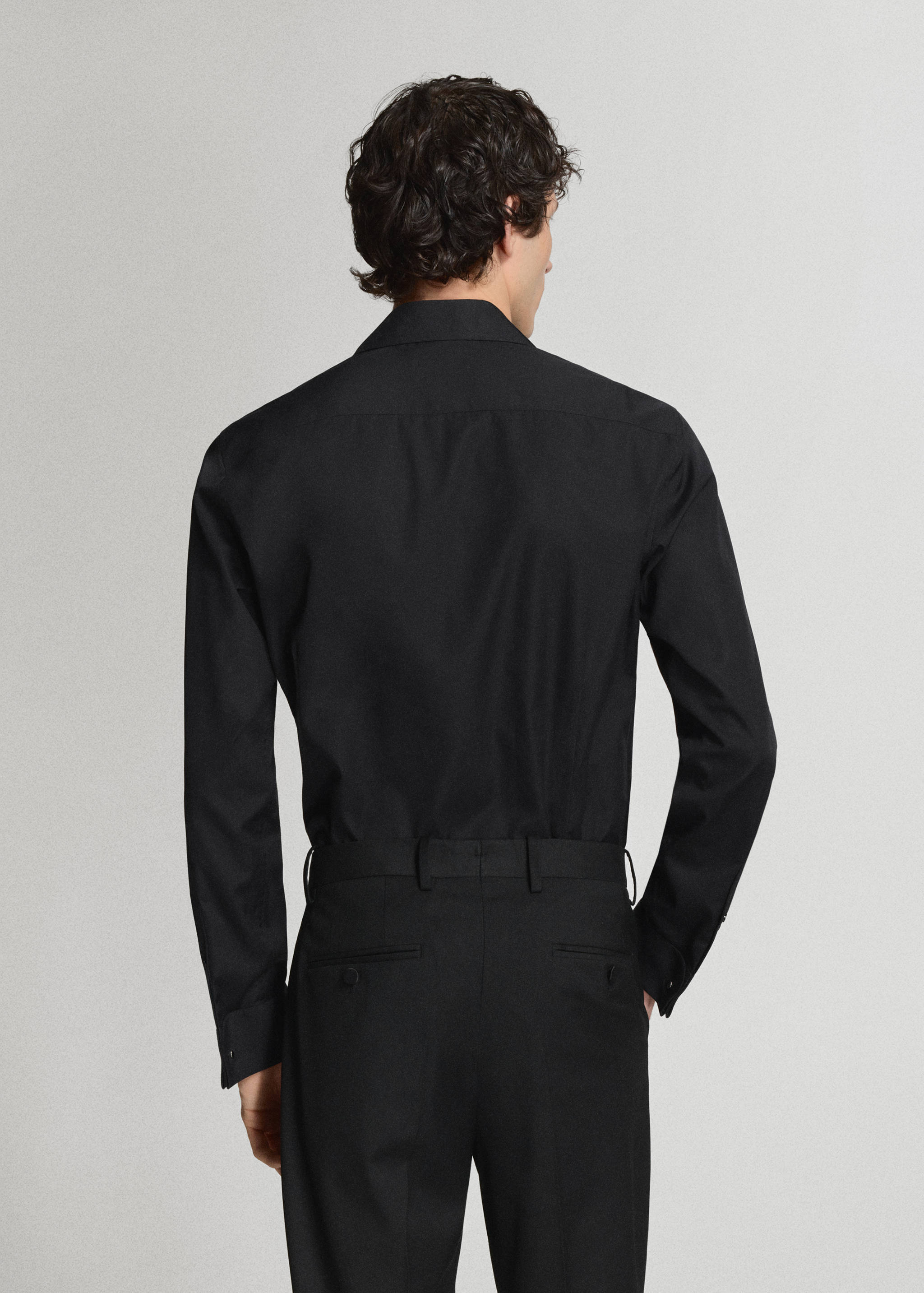 Back view of a black long-sleeved shirt with a classic collar.