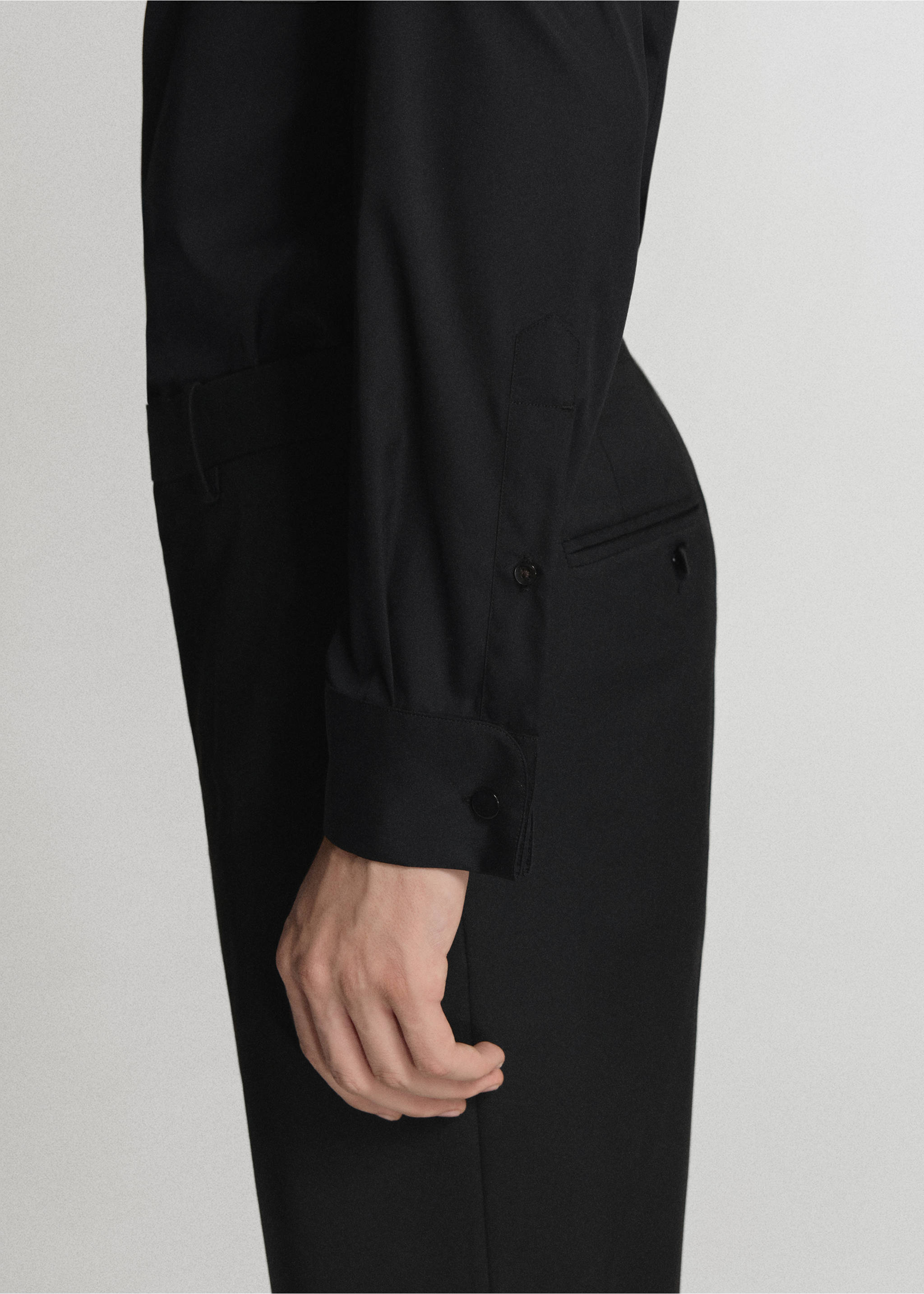 Black long-sleeved shirt detail showcasing the cuffed sleeve and button placket., Black. Ref: 47071335-00.