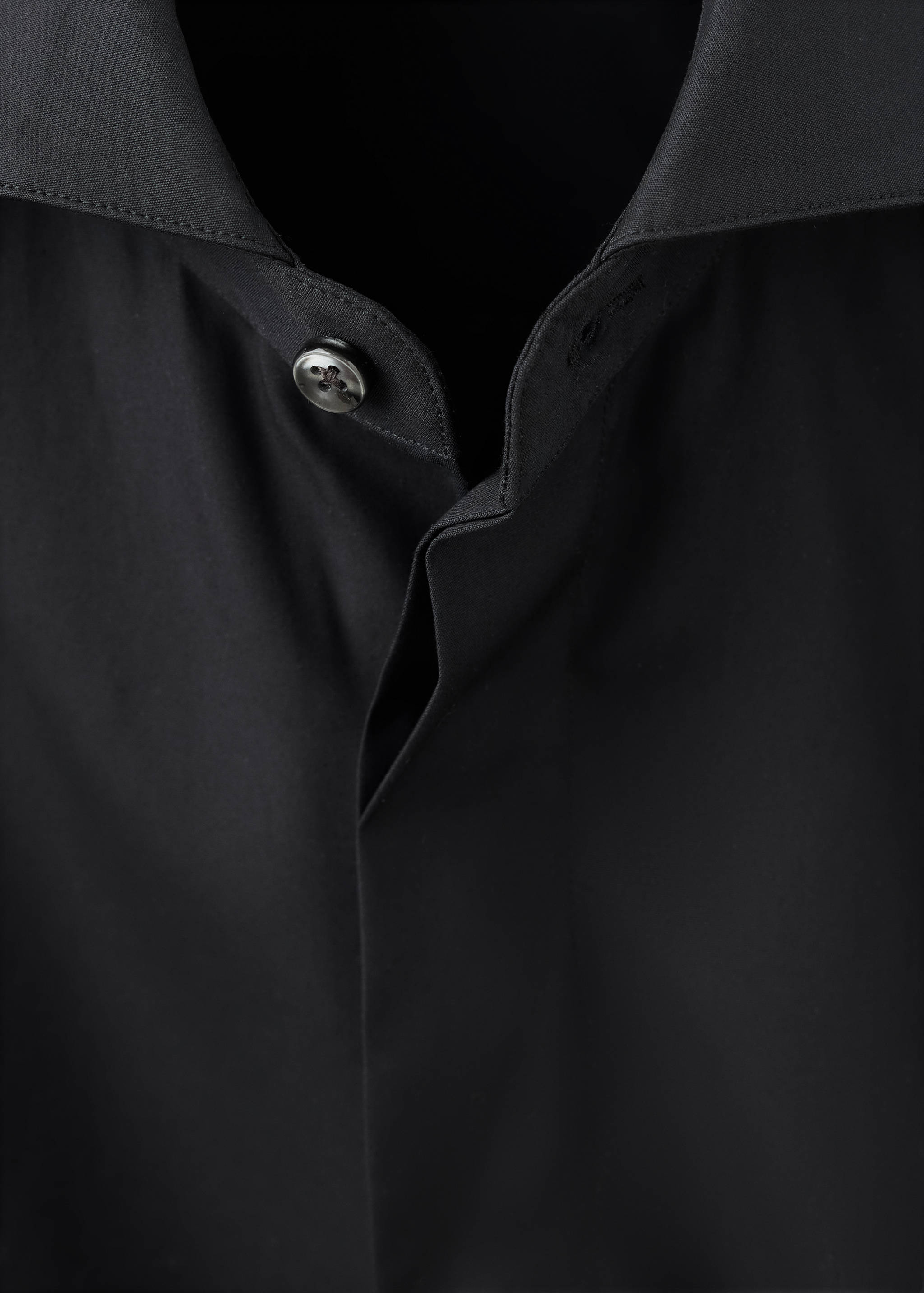 Close-up of a black shirt collar and button placket.