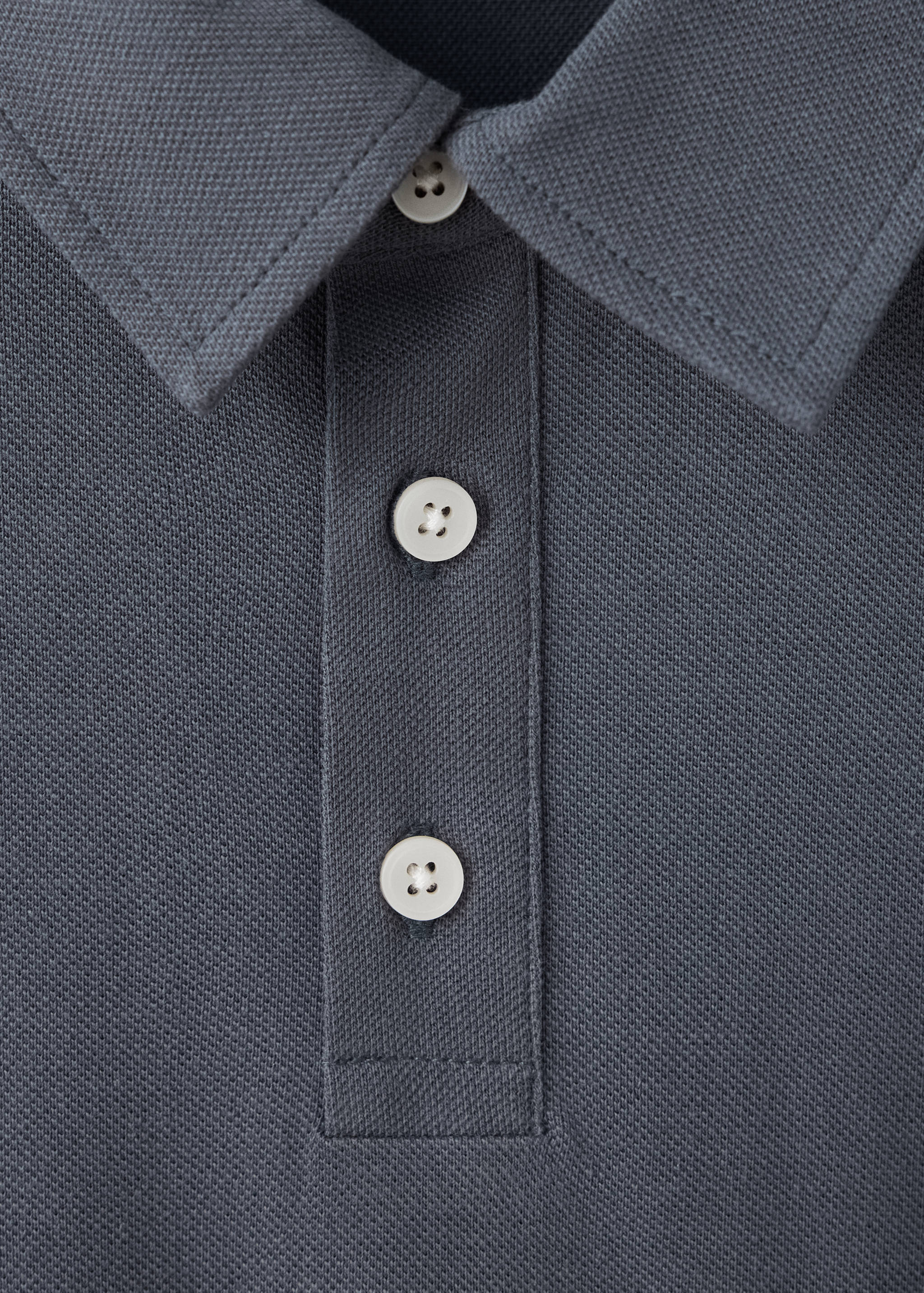 Close-up of a dark grey piqué polo shirt collar and button placket.