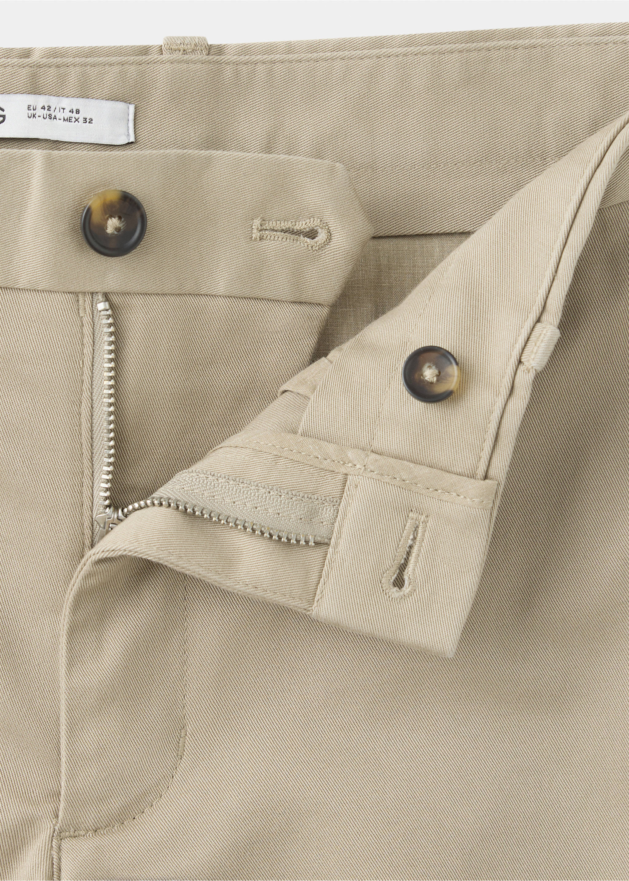 Close-up of beige trousers showing the waistband, zip fly and tortoiseshell button., Beige. Ref: 47071351-00.