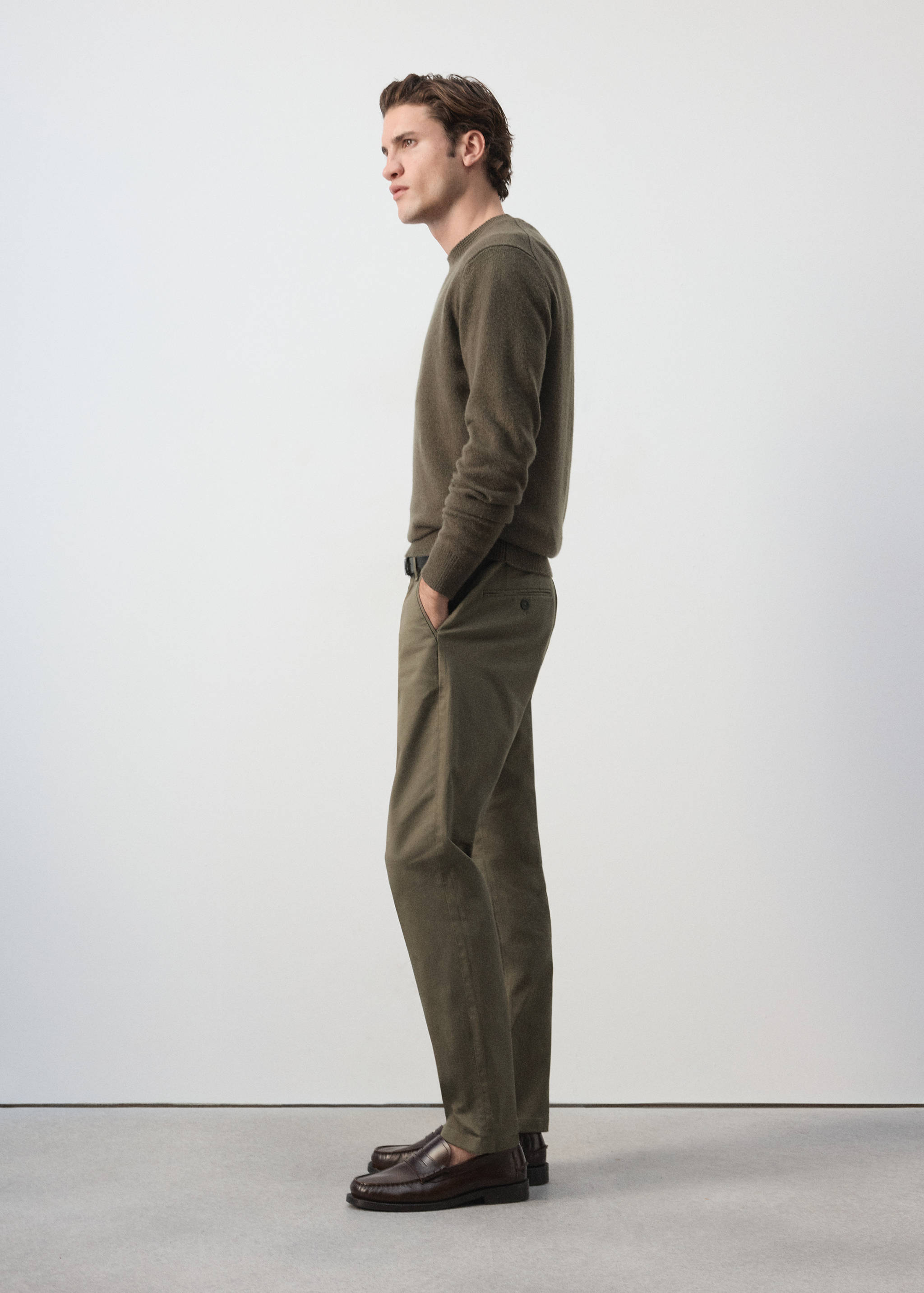 Dark khaki trousers with a straight-leg fit, worn with a matching sweater.