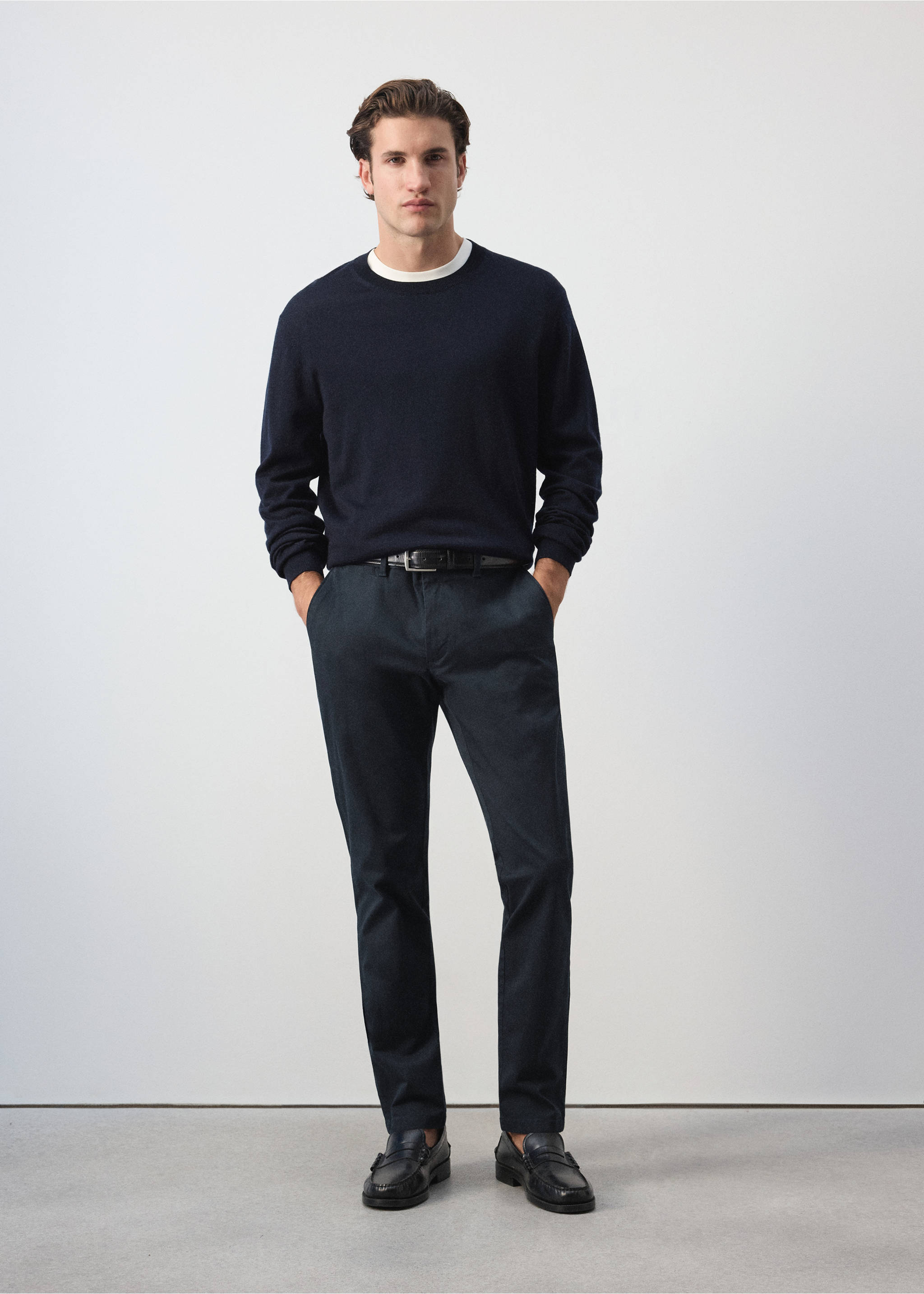 Dark navy blue slim-fit trousers worn with a crew-neck sweater., Navy. Ref: 47071351-00.