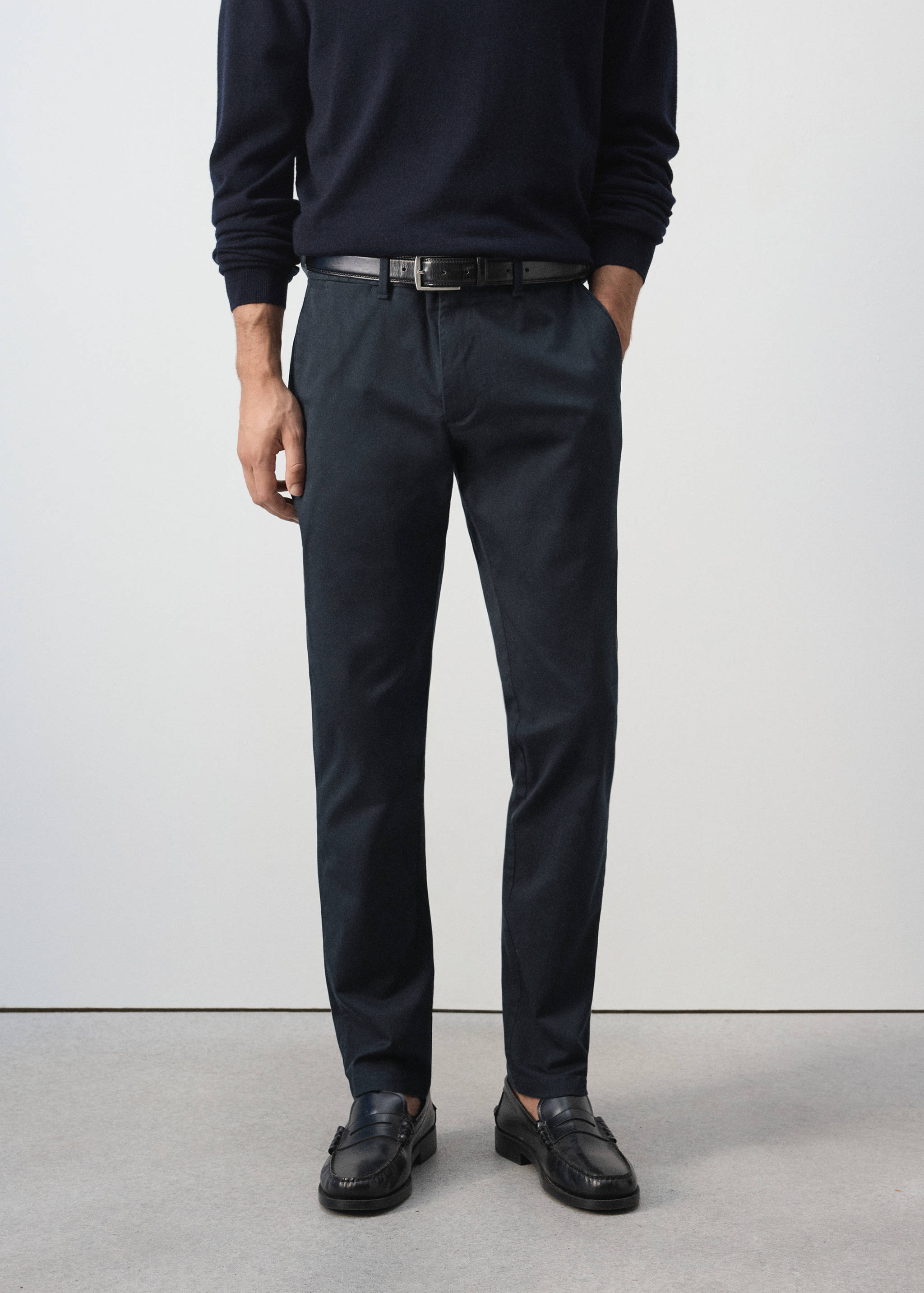 Dark navy blue straight-leg trousers worn with a dark sweater and black belt.