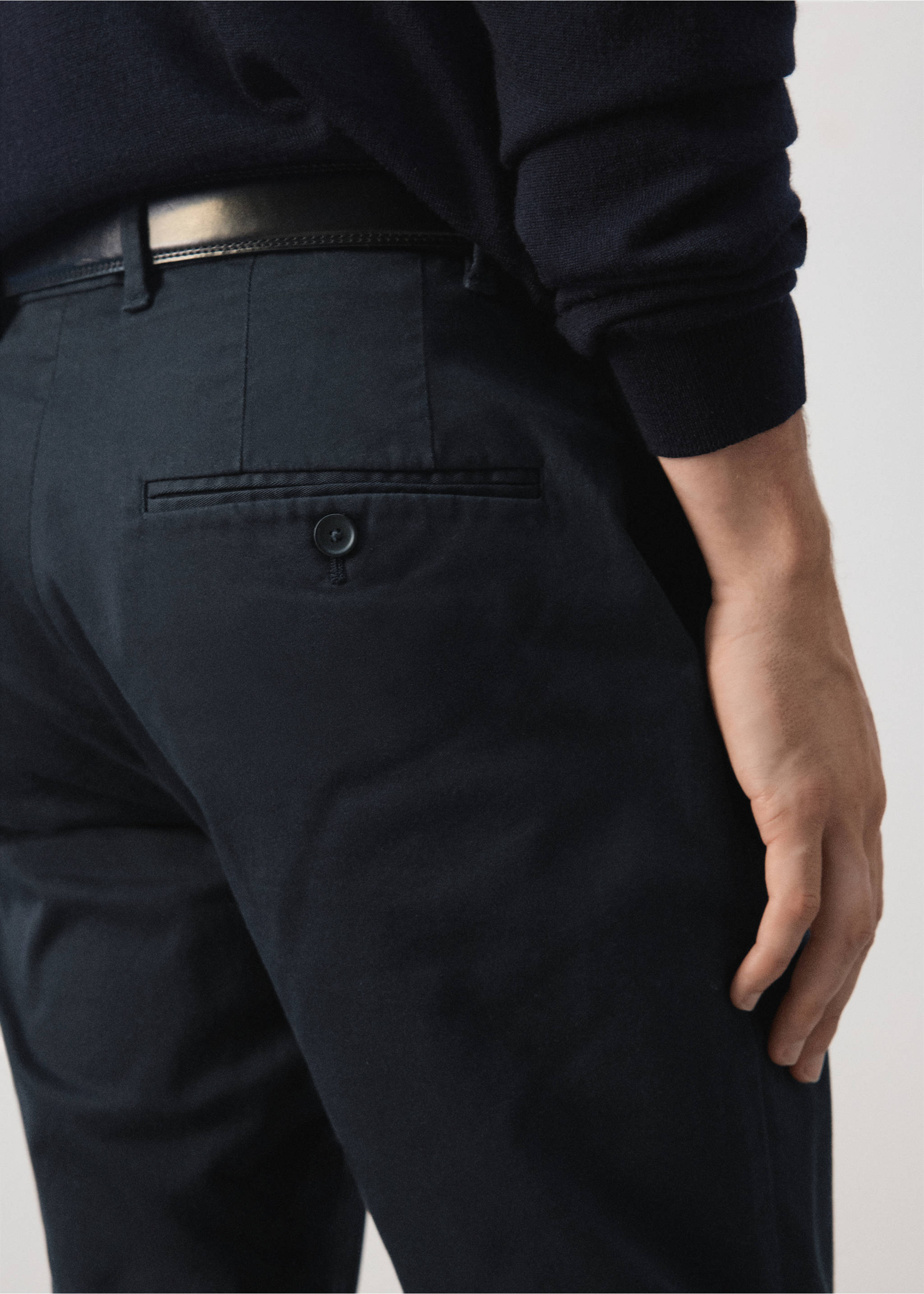 Dark blue trousers with a button-fastening back pocket, worn with a belt., Navy. Ref: 47071351-00.