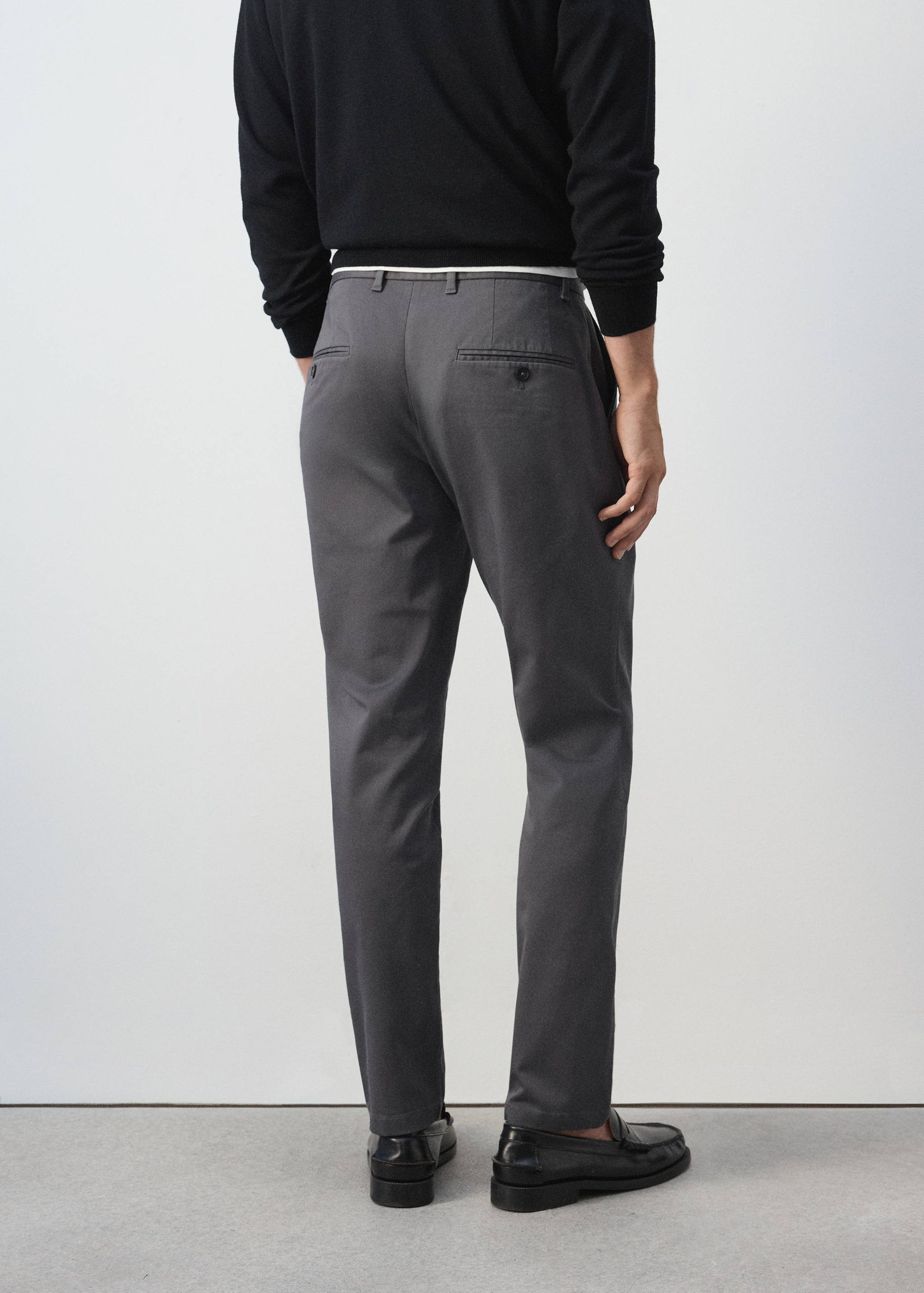 Dark grey trousers, seen from the back, featuring belt loops and welt pockets.