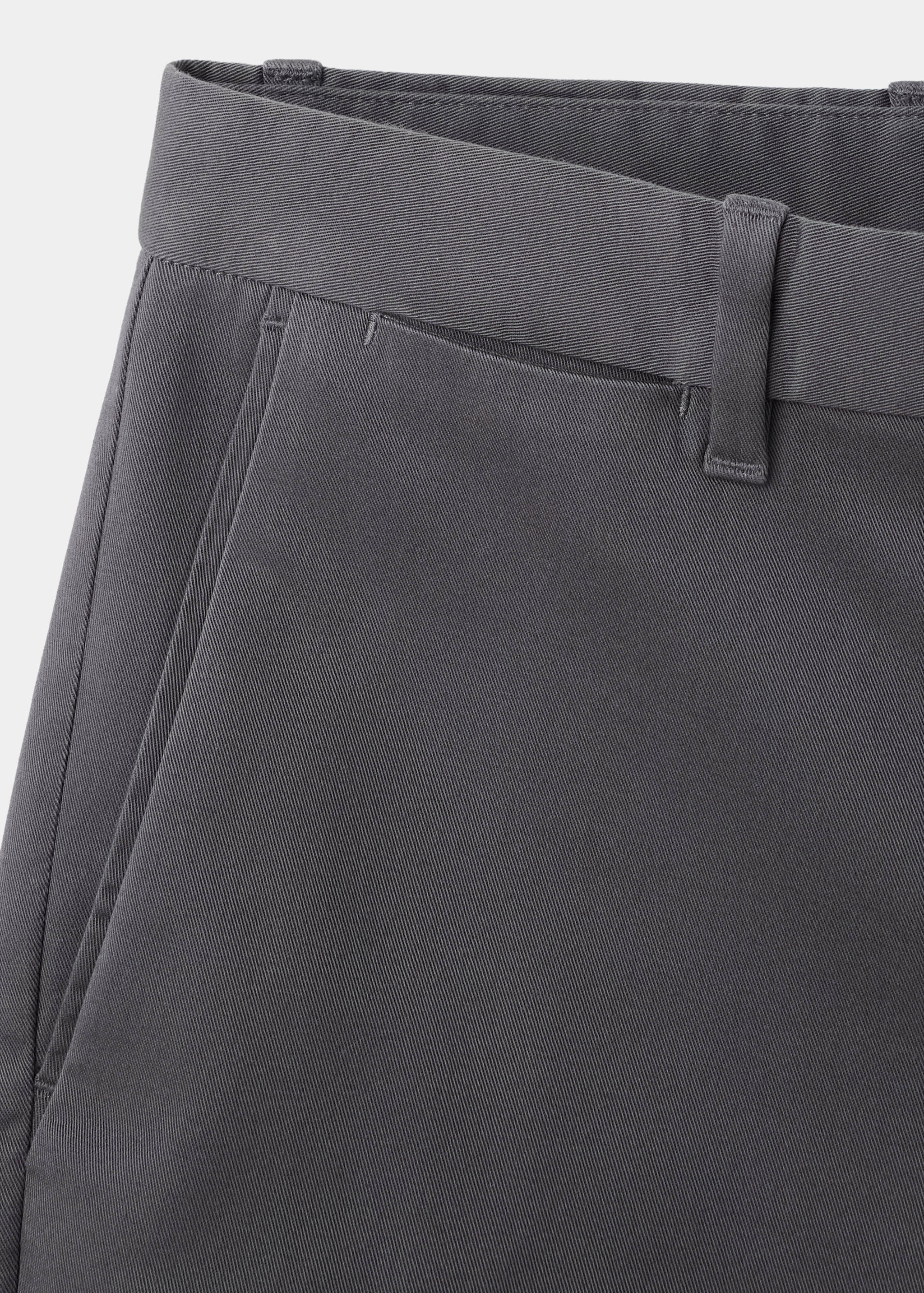 Dark grey trousers waistband and side pocket detail.
