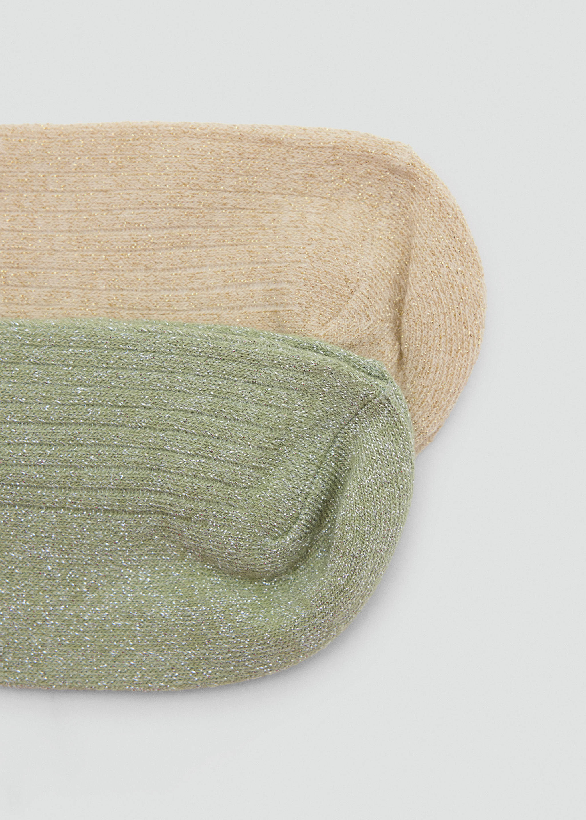 Close-up of beige and green ribbed metallic socks.