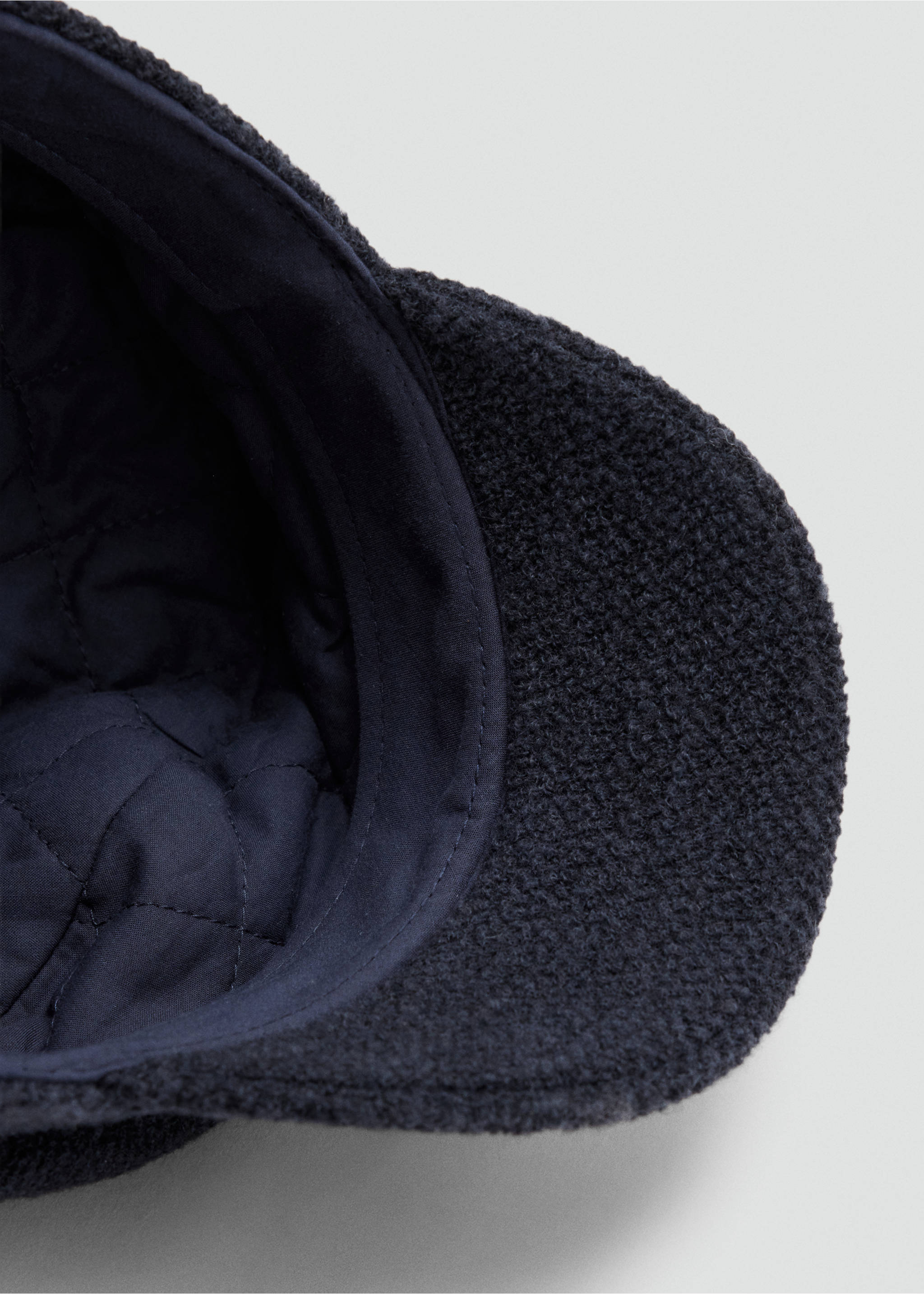 Close-up of the quilted lining and textured visor of a navy blue sailor cap., Navy. Ref: 47071357-00.
