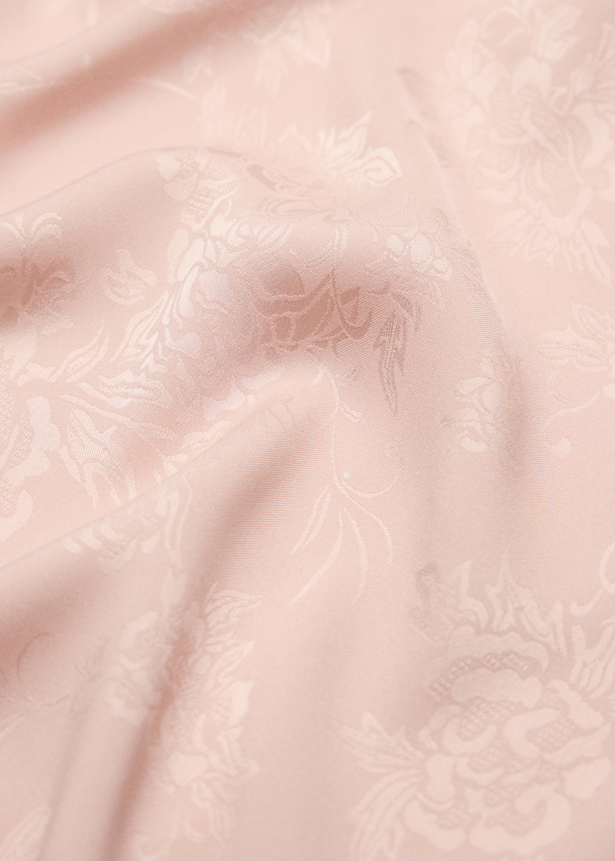 Pink scarf close-up showing a tonal jacquard floral pattern.