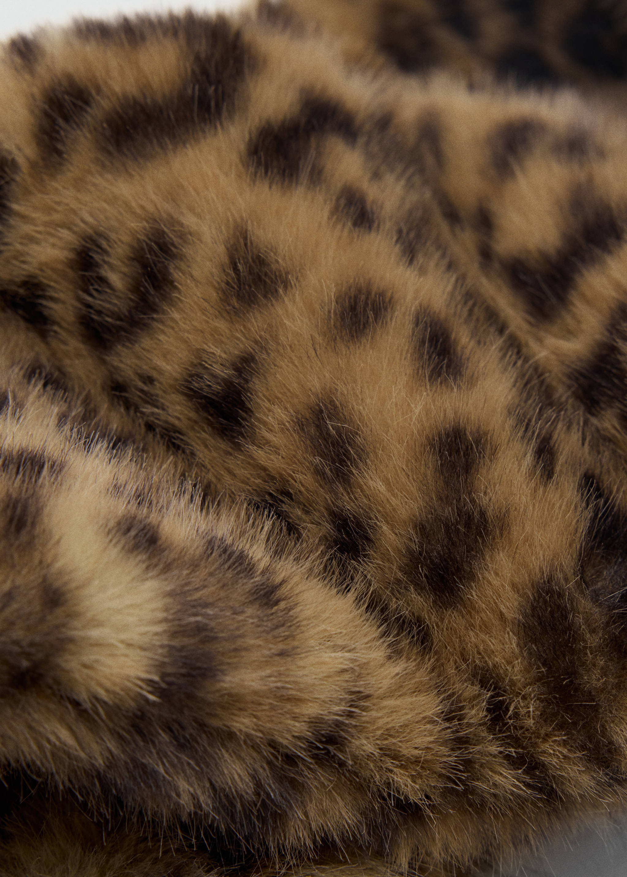 Leopard print faux-fur scarf in a close-up detail view.