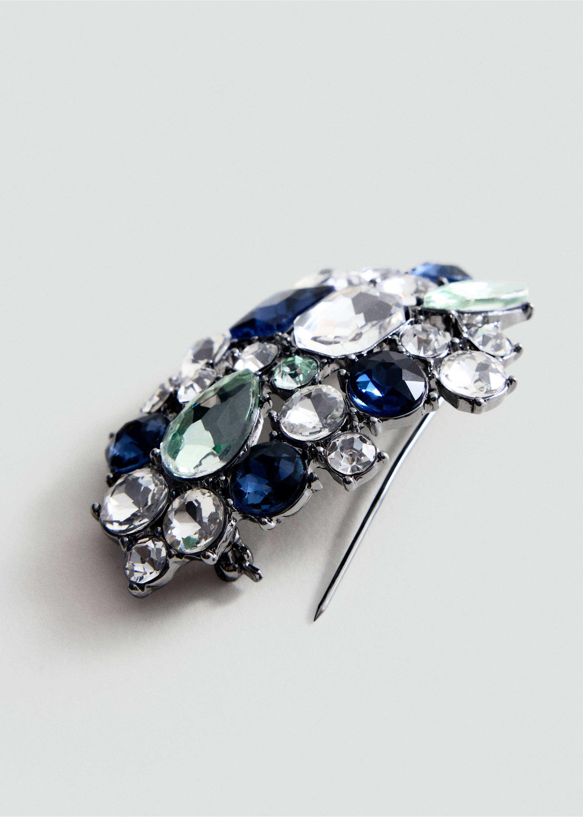 Brooch with blue, clear and green crystals in a dark metallic setting., Silver. Ref: 47081386-00.