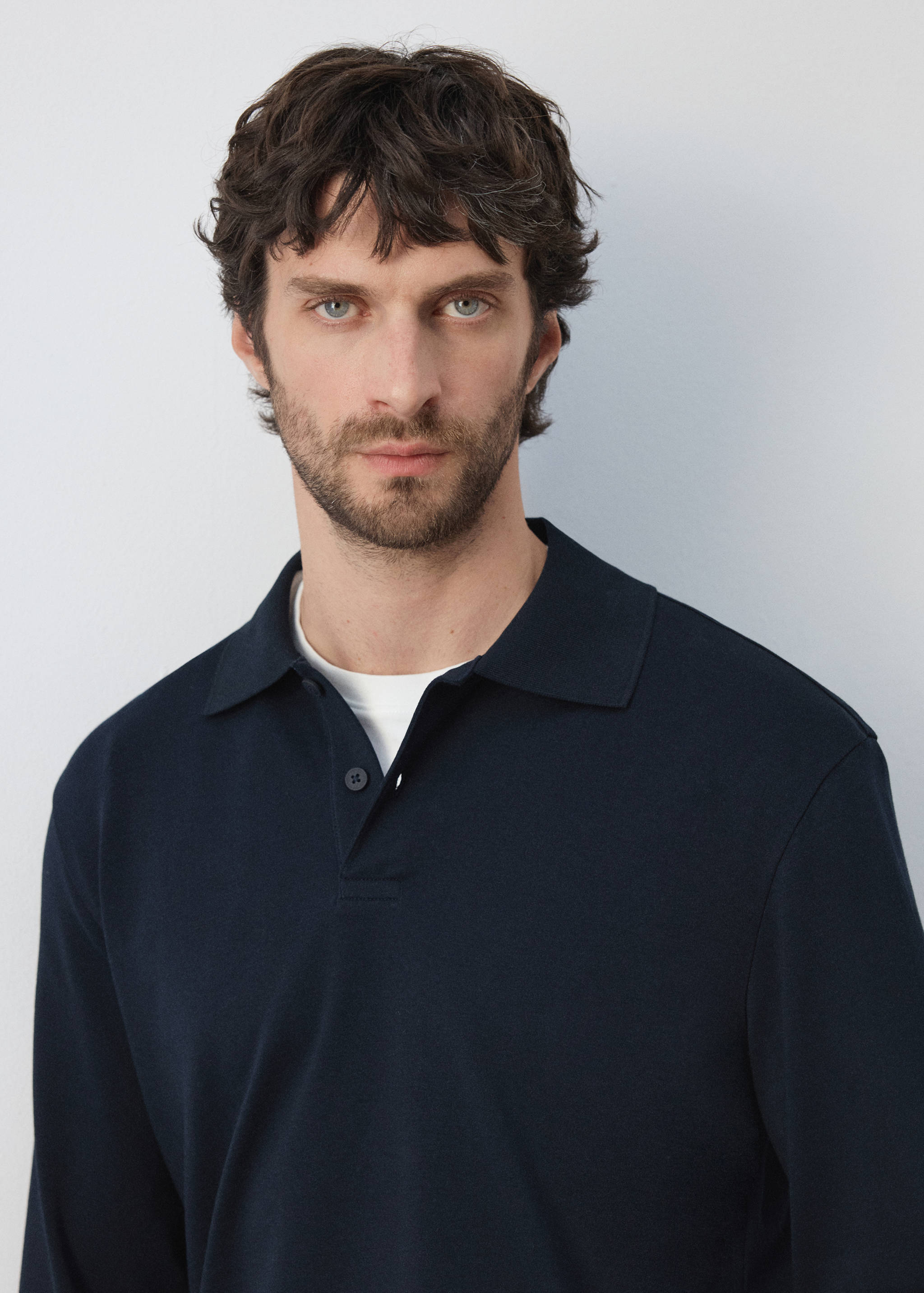 Close-up of a navy blue polo shirt with a buttoned placket.