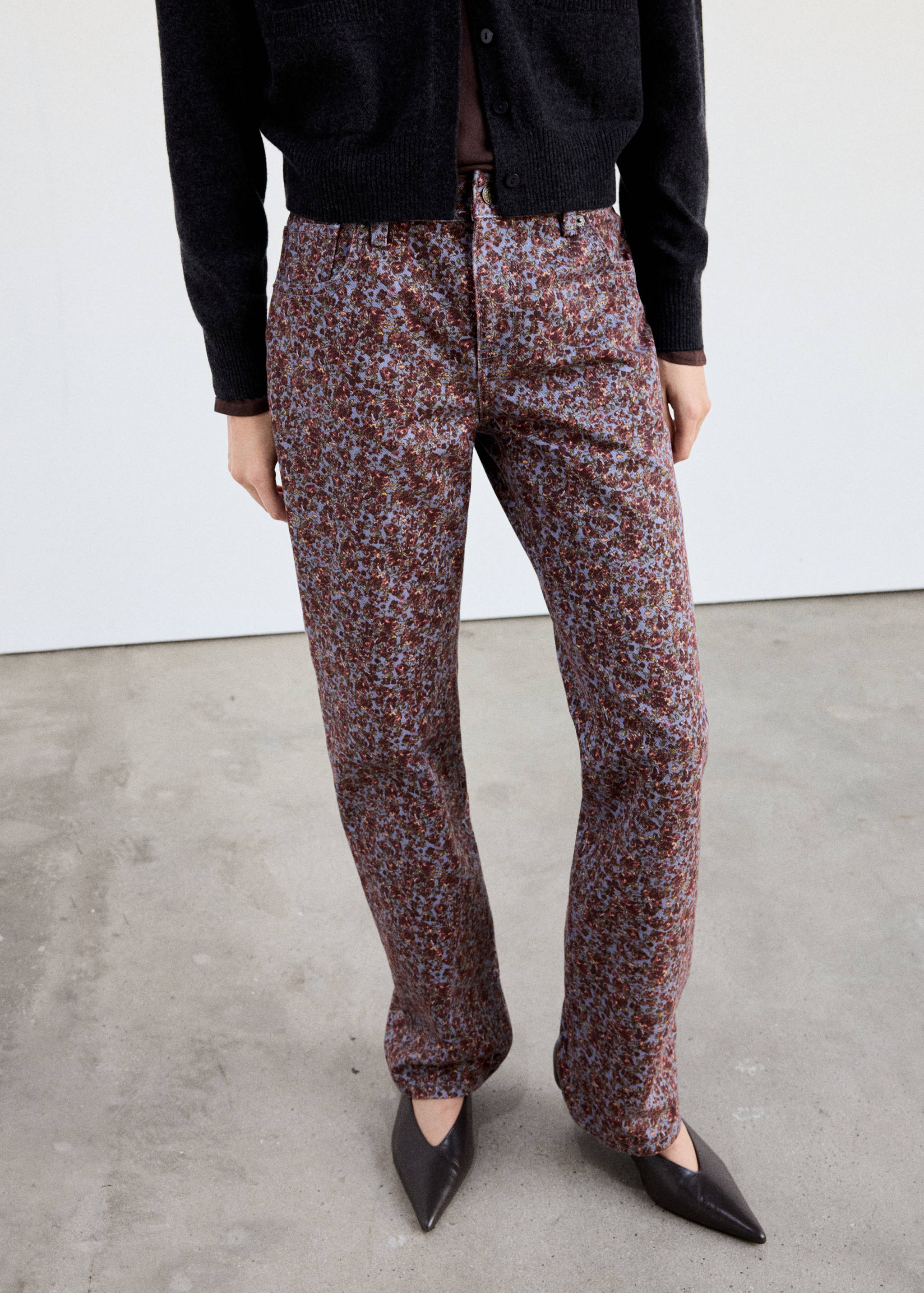 Printed denim trousers with a light blue floral pattern.