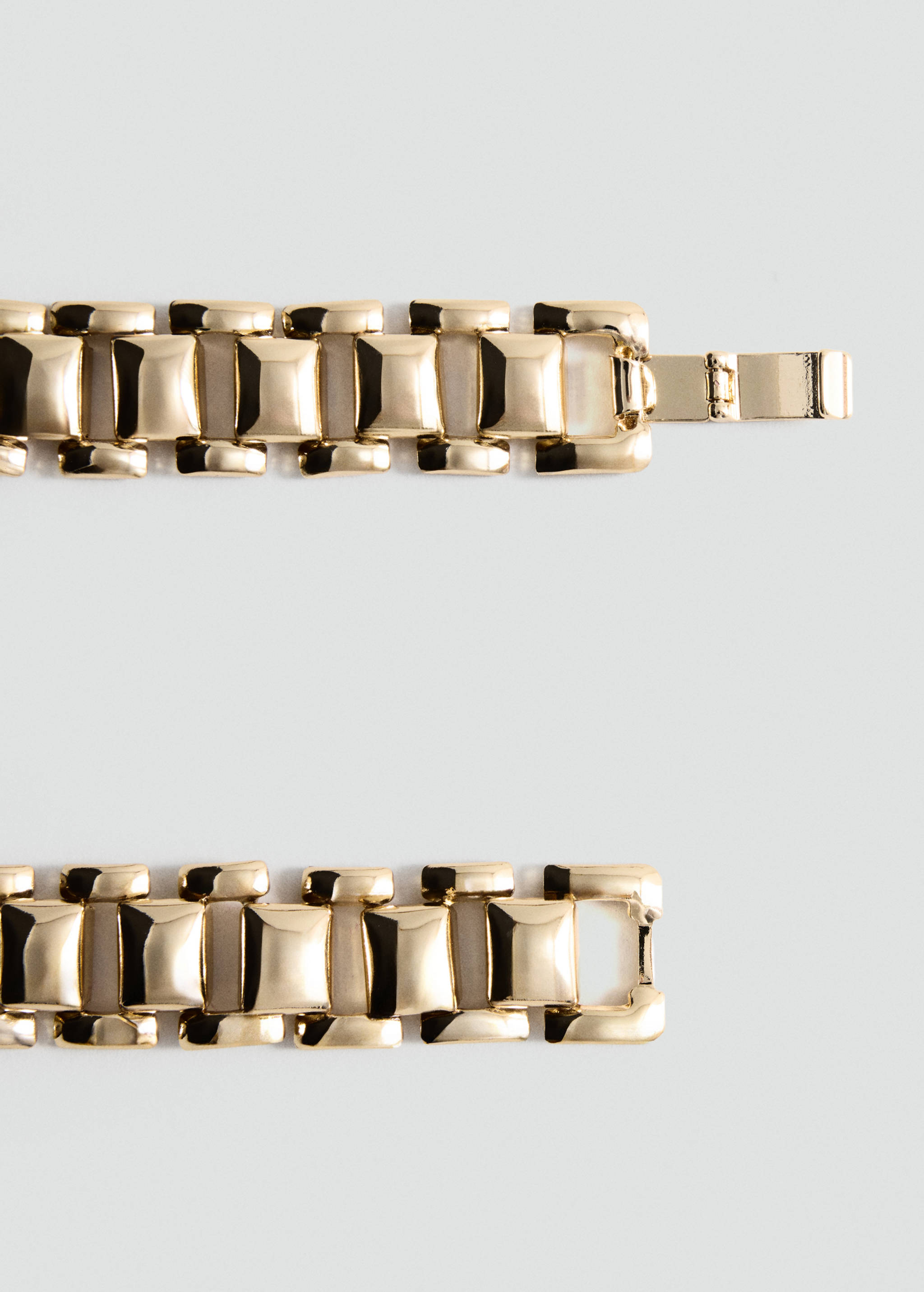 Close-up of a gold-coloured metallic link collar accessory.