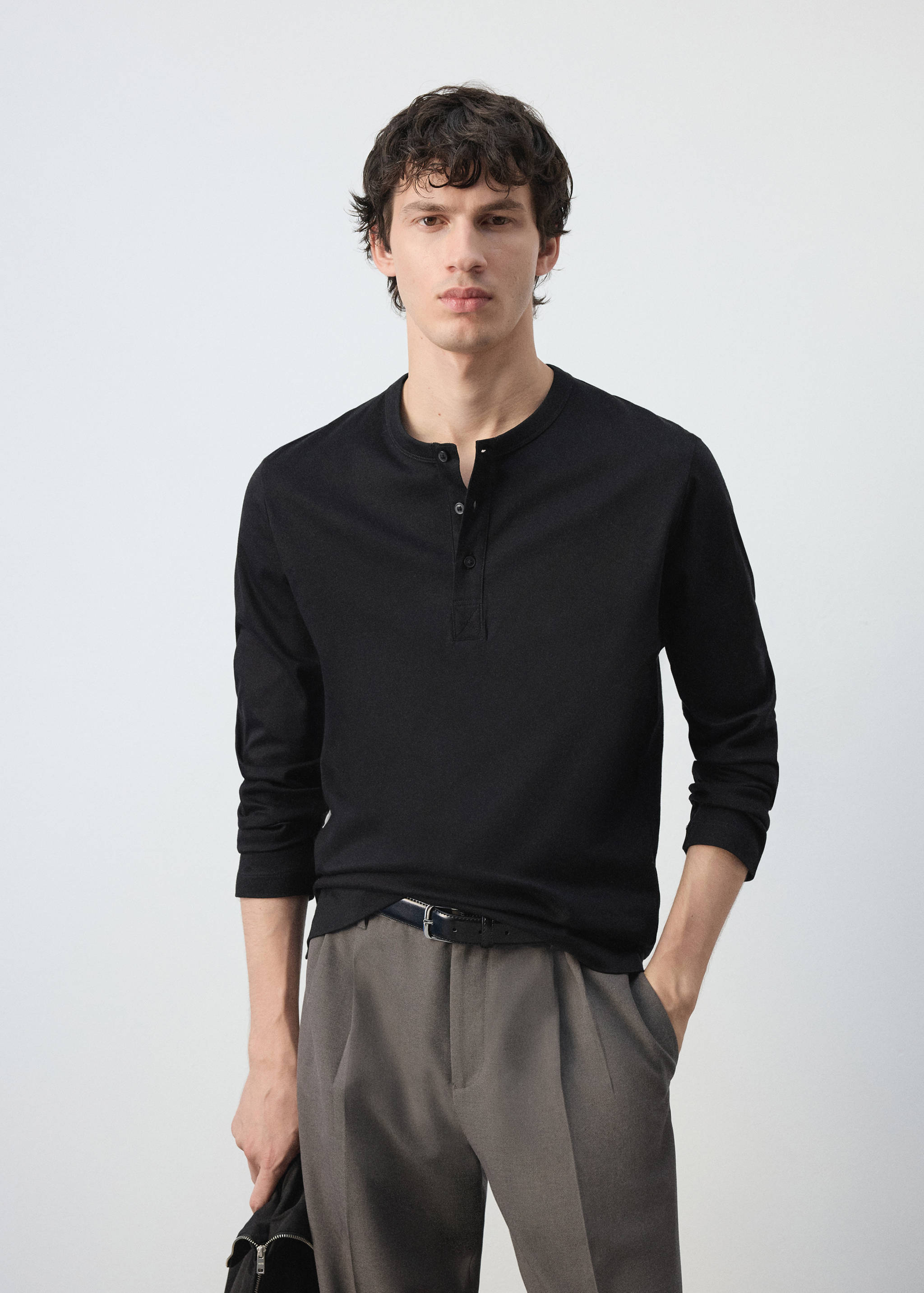 Camiseta henley negra de manga larga con cartera de botones.