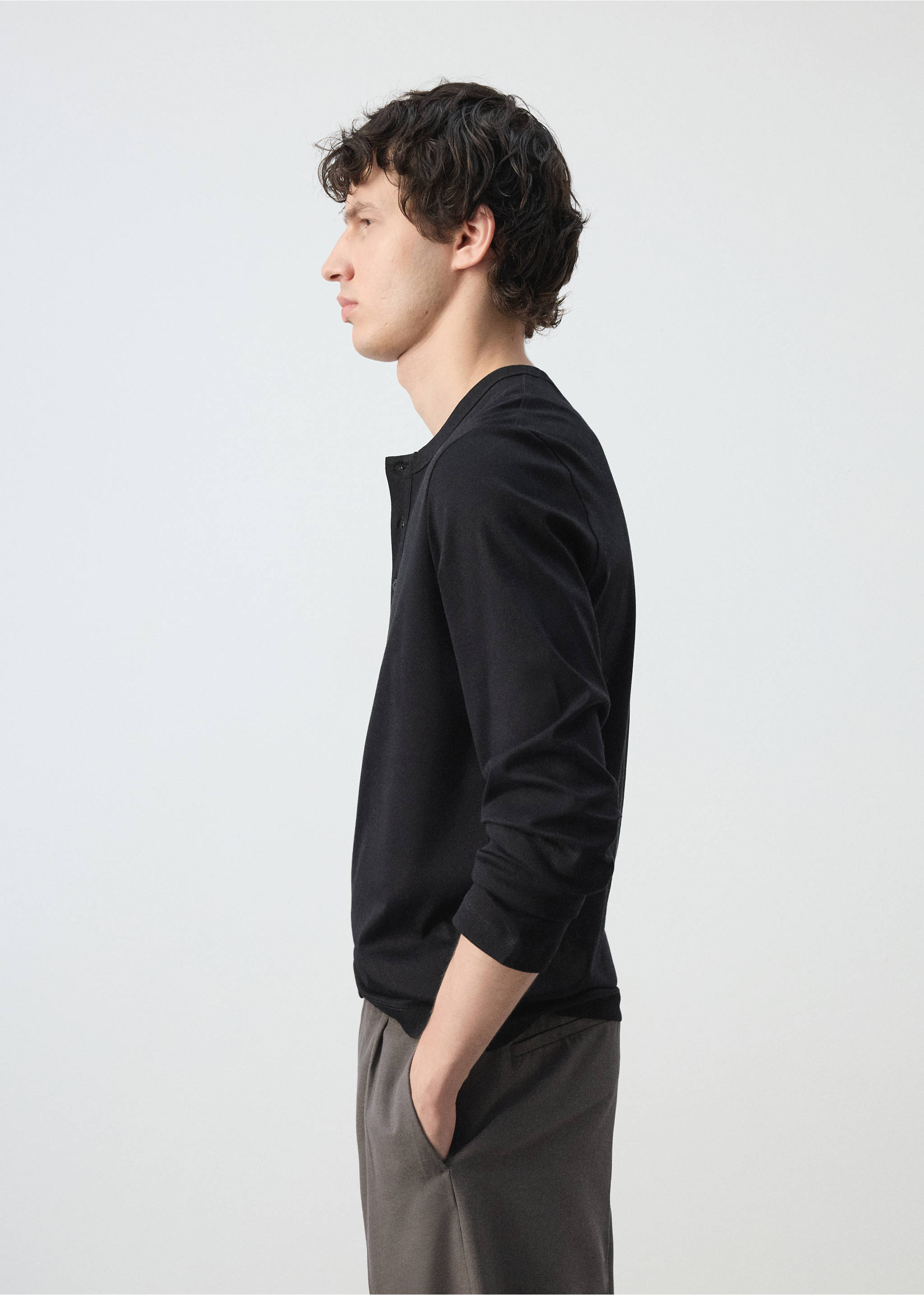 Black long-sleeve t-shirt with a henley neckline, shown in profile., Black. Ref: 47091350-00.