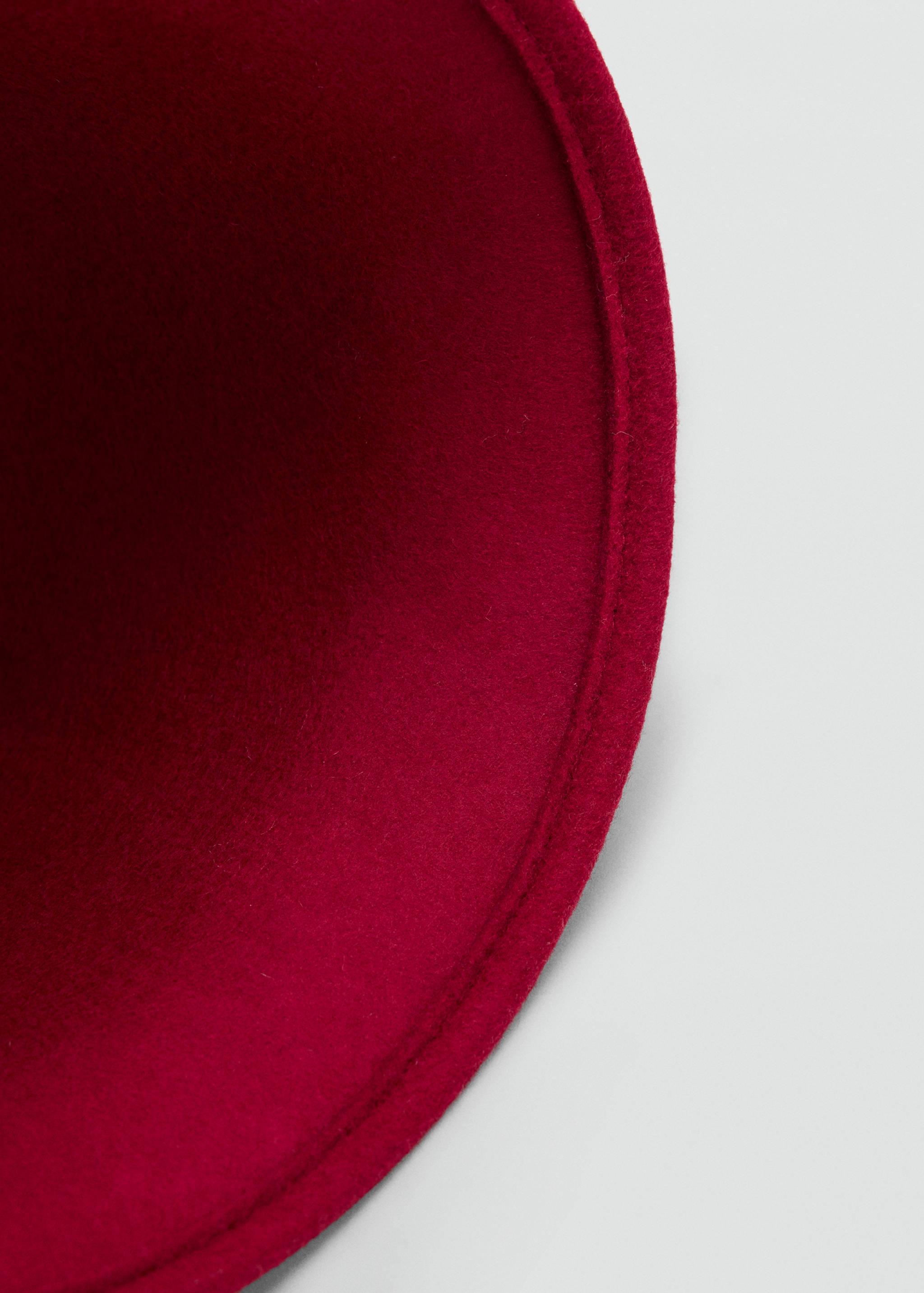 Close-up of a deep red felt hat showing interior detail.