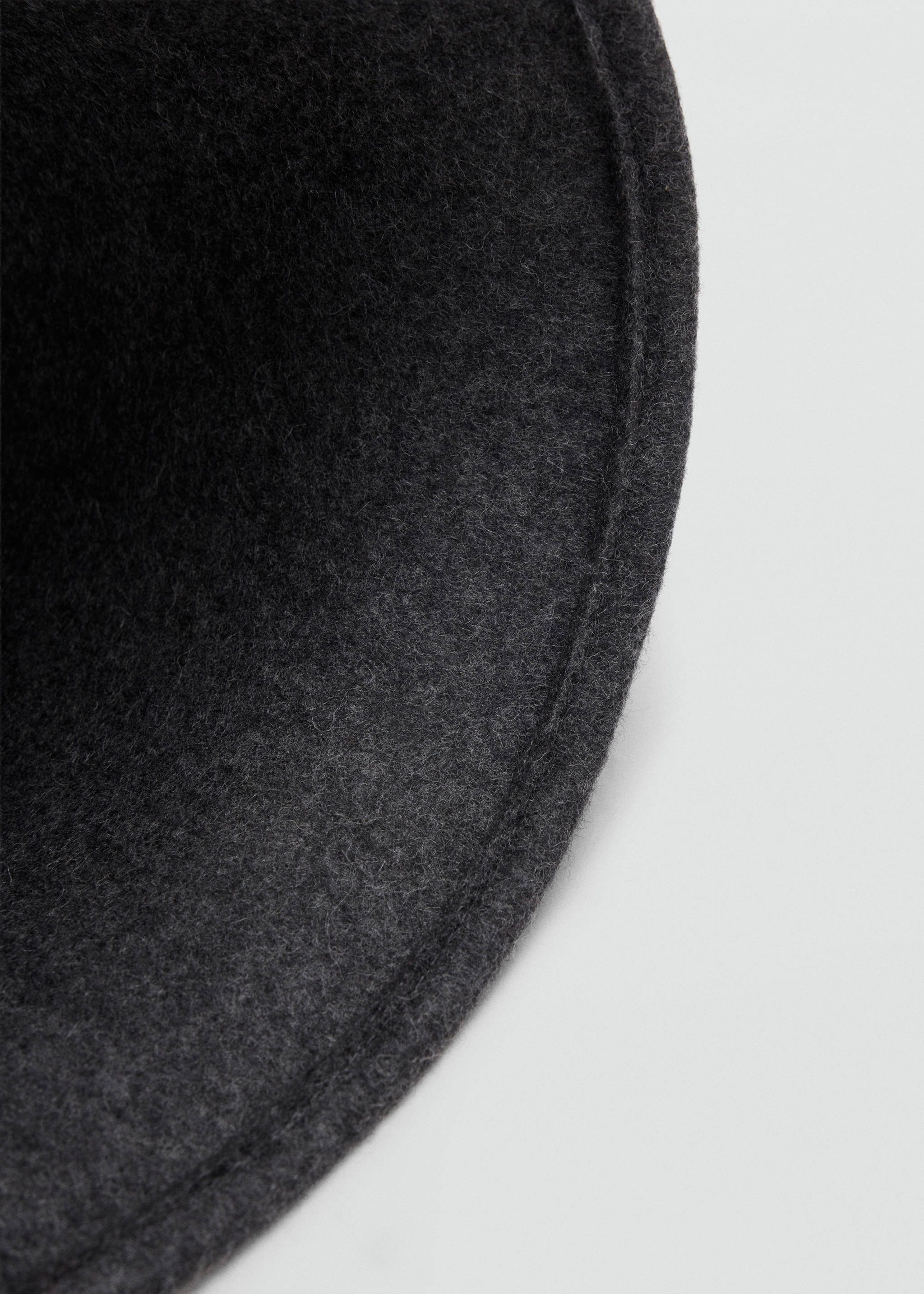 Close-up of a dark grey felt hat brim showing its texture.