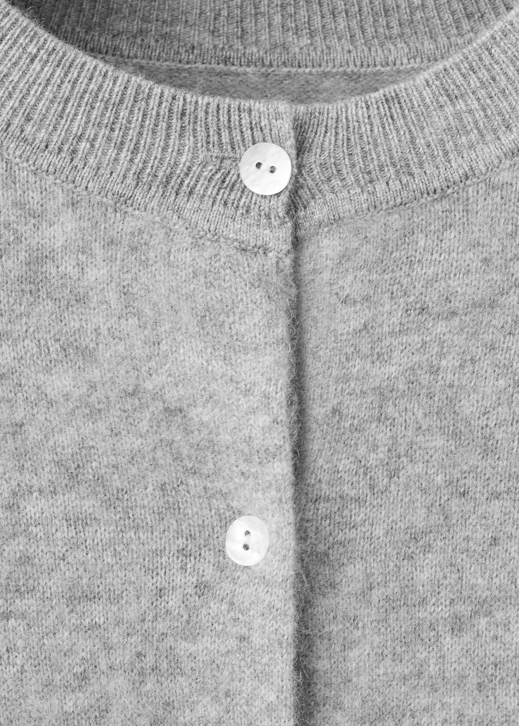 Grey knit cardigan with a round neckline and button fastening.