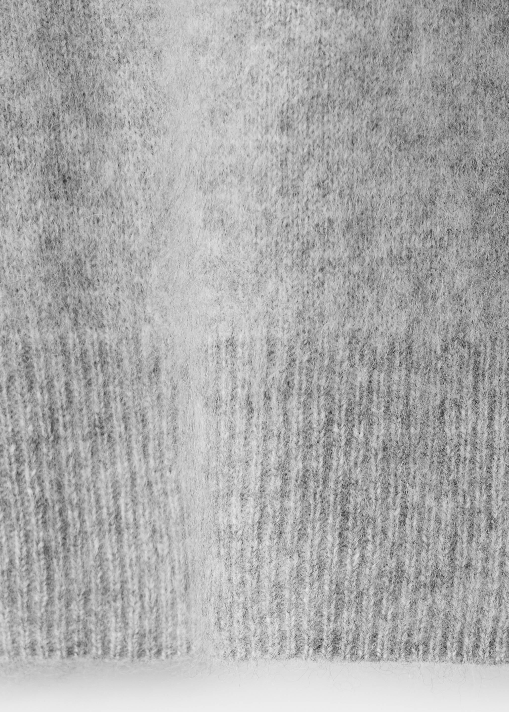 Grey cardigan fabric detail showing a soft, fuzzy knit and ribbed hem.