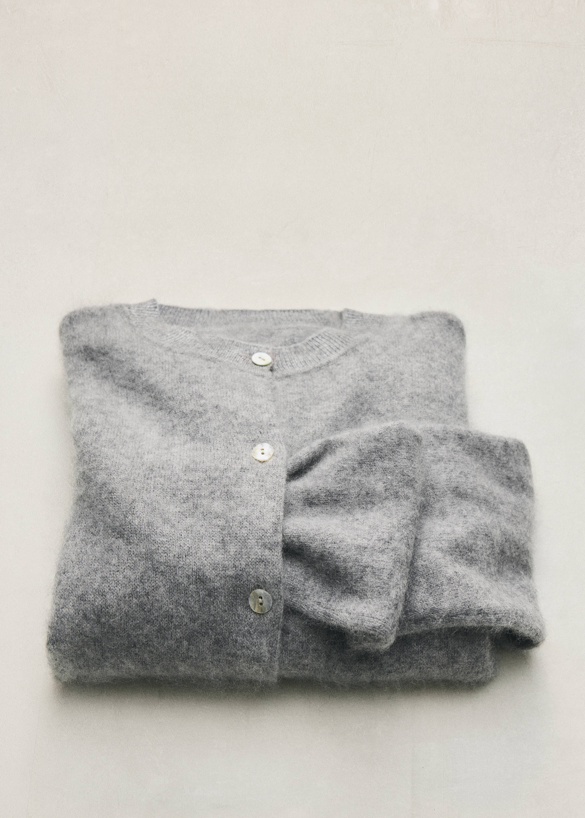 Grey knitted cardigan with a round neckline and button fastening.