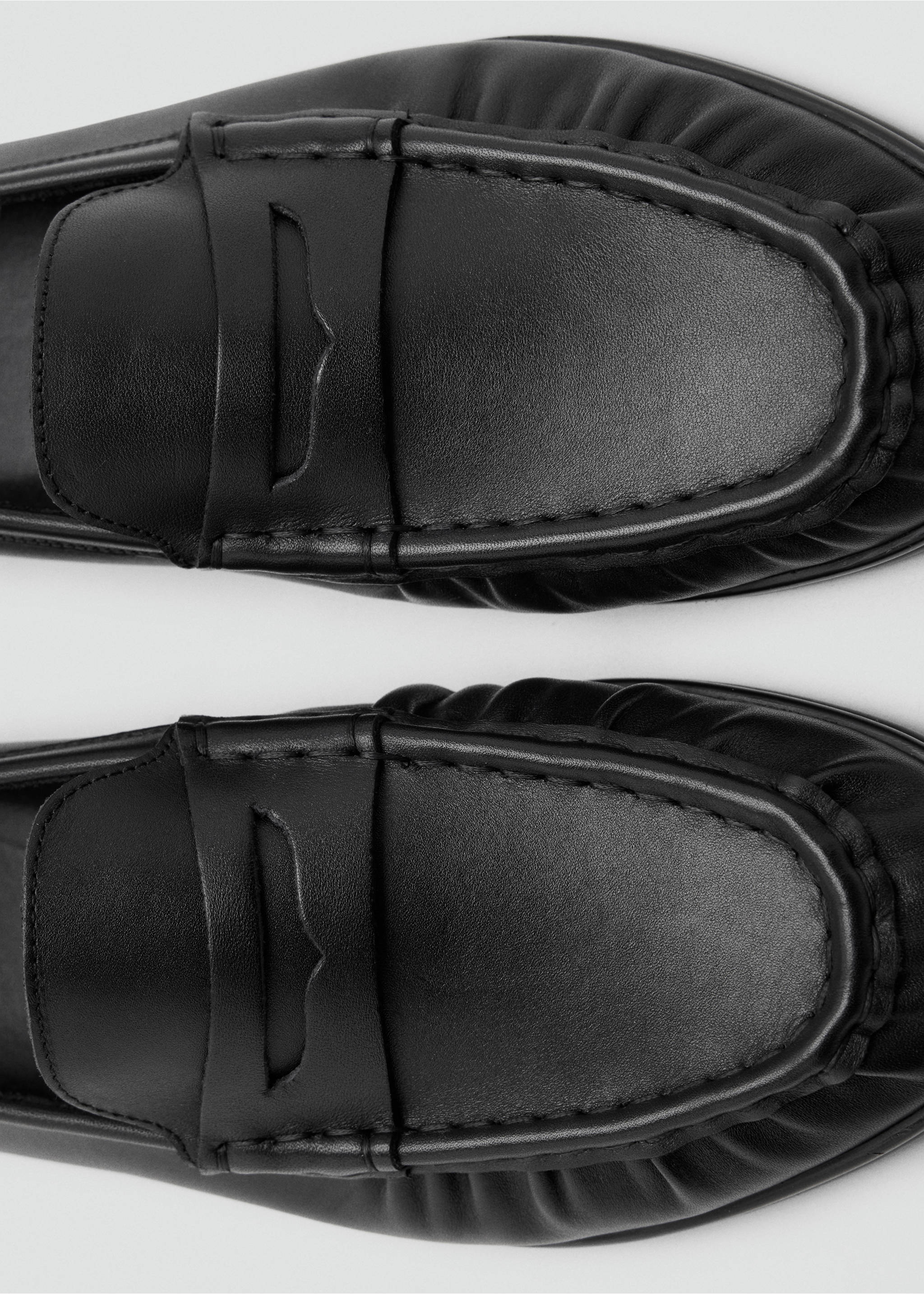 Close-up of black leather loafers with traditional strap detail., Black. Ref: 47091370-00.