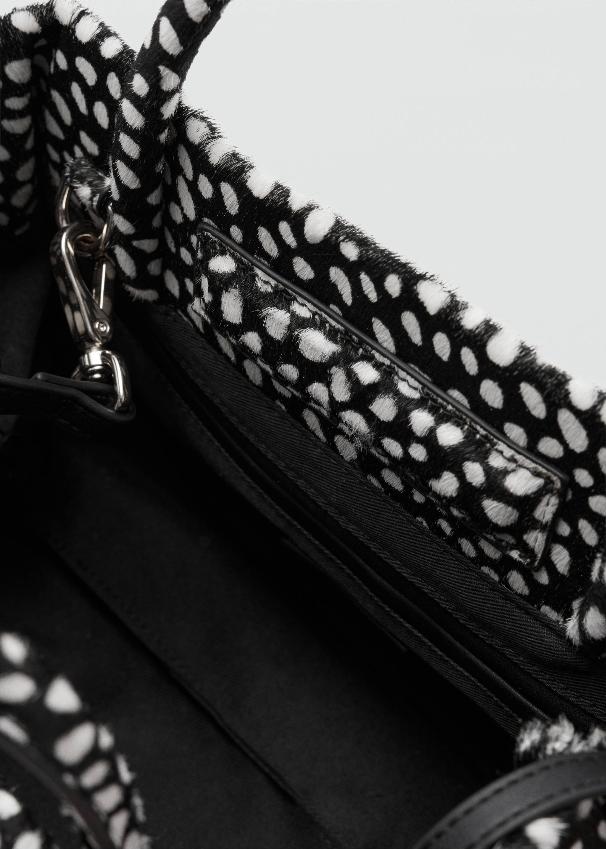 Close-up of a black and white animal-print handbag interior detail., Black. Ref: 47091375-00.
