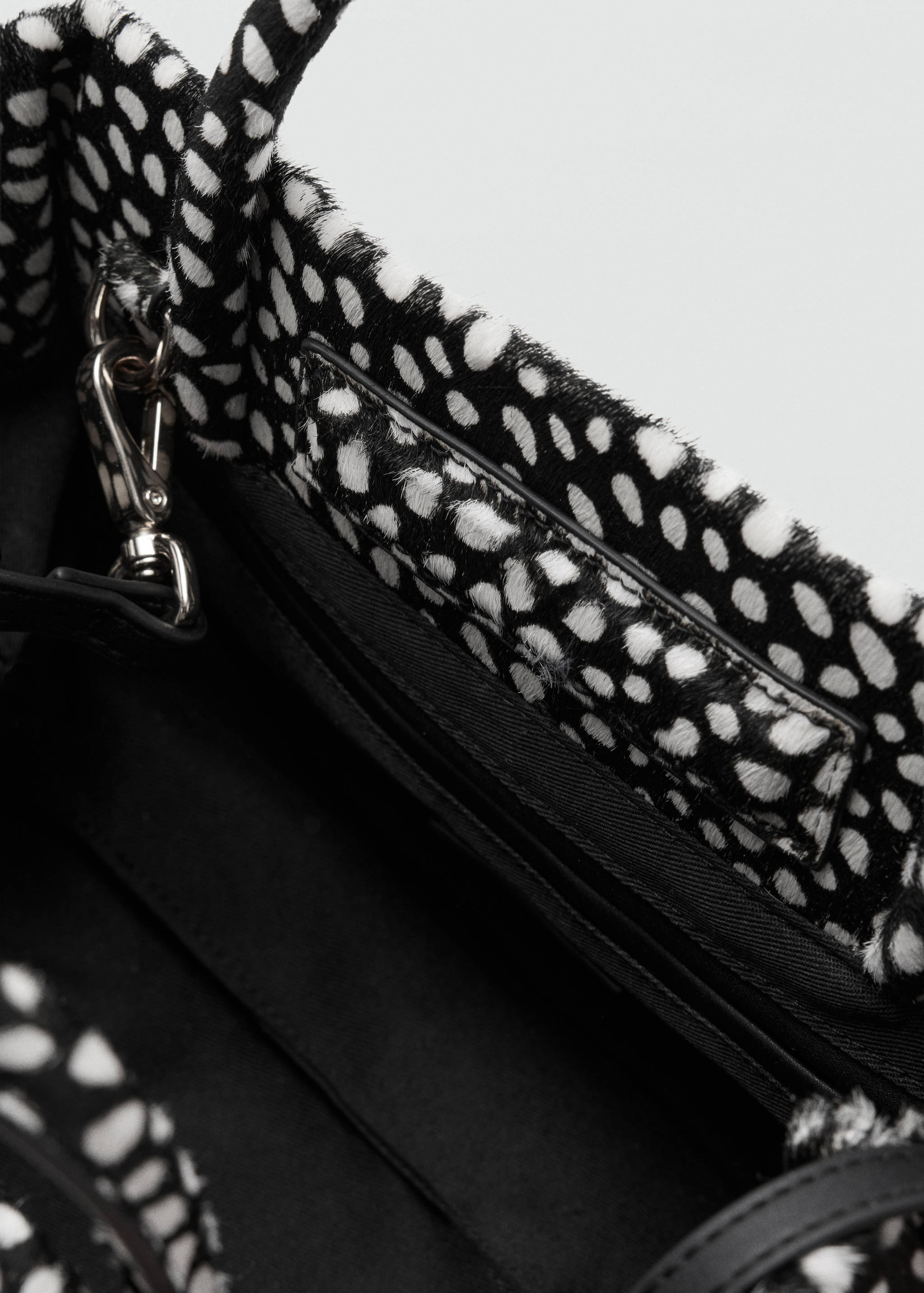 Close-up of a black and white animal-print handbag interior detail.
