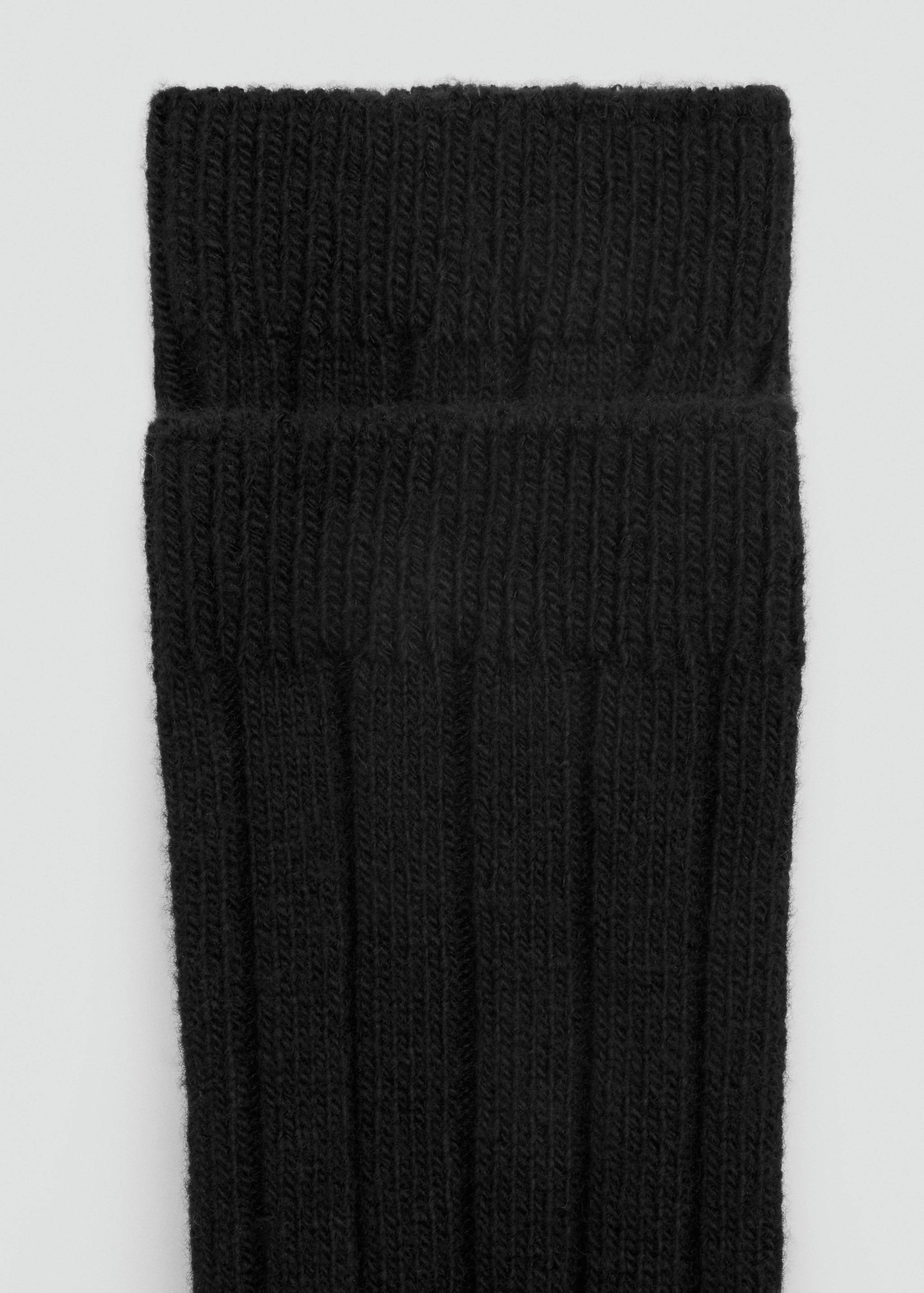 Calcetines de punto negros con caña ancha de canalé y canalé vertical.