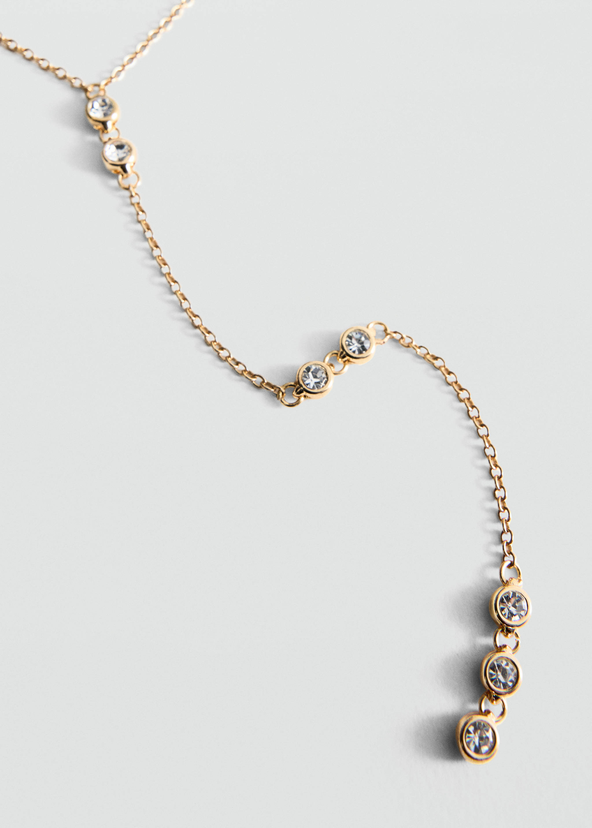 Collar rígido de metal dorado con cristales engastados en bisel.