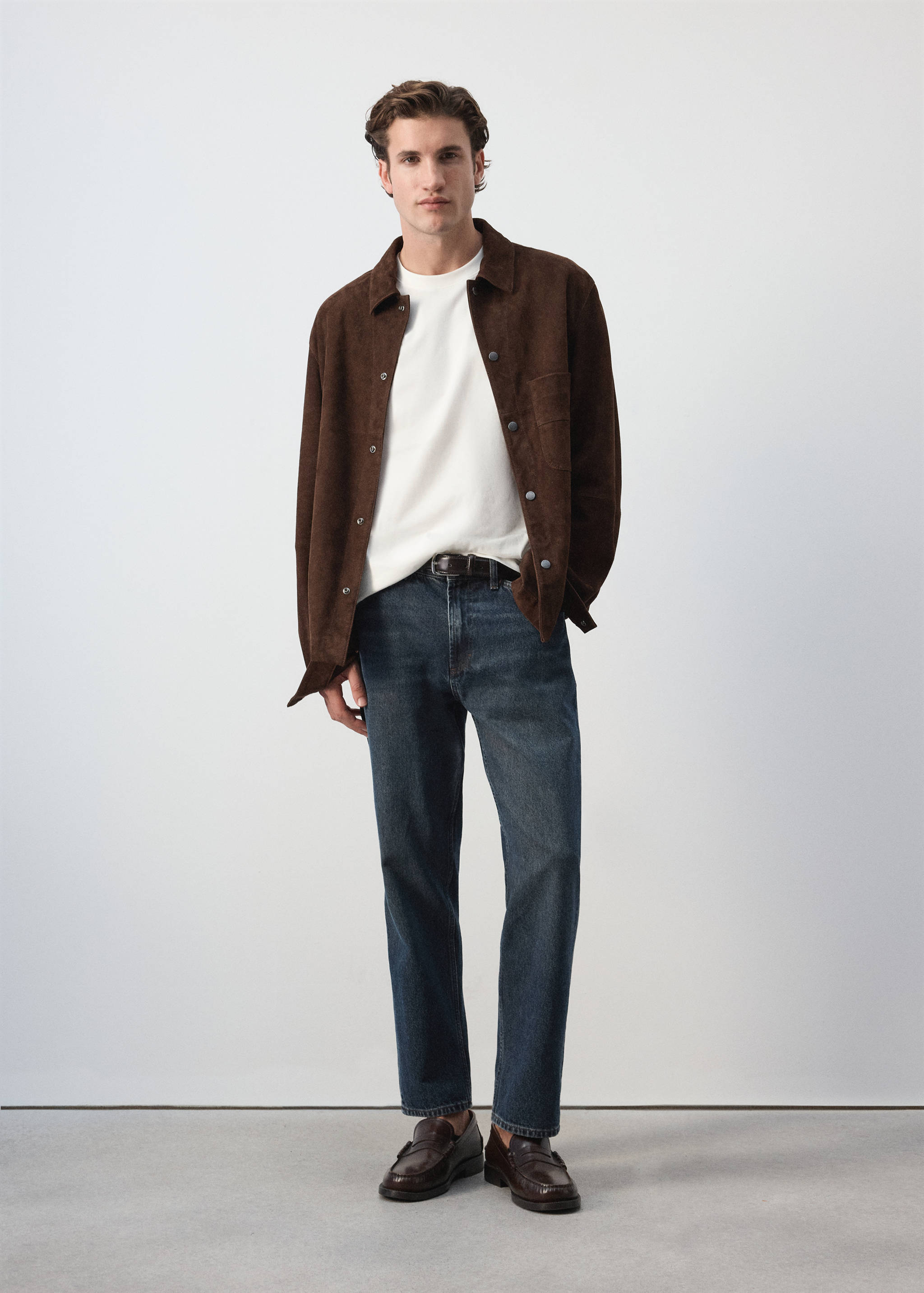 White t-shirt worn with a brown overshirt and blue jeans.