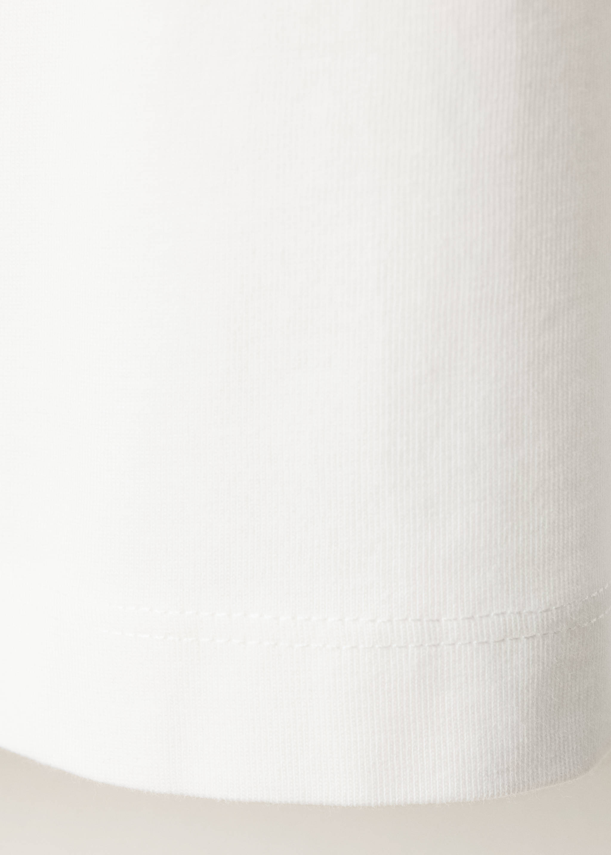 Close-up of the white t-shirt fabric and hem detail.