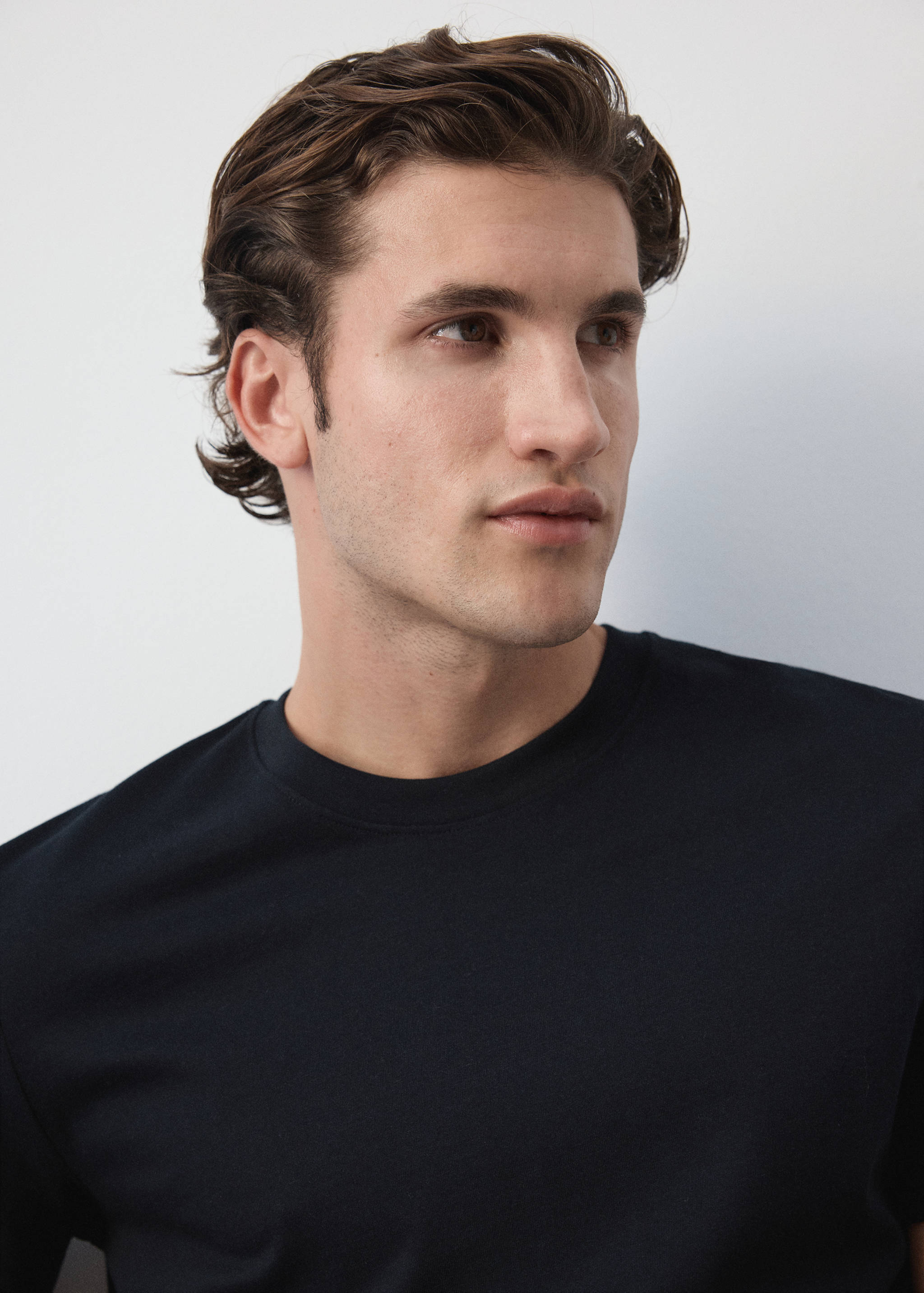 Close-up of a dark navy blue t-shirt with a crew neck on a model.