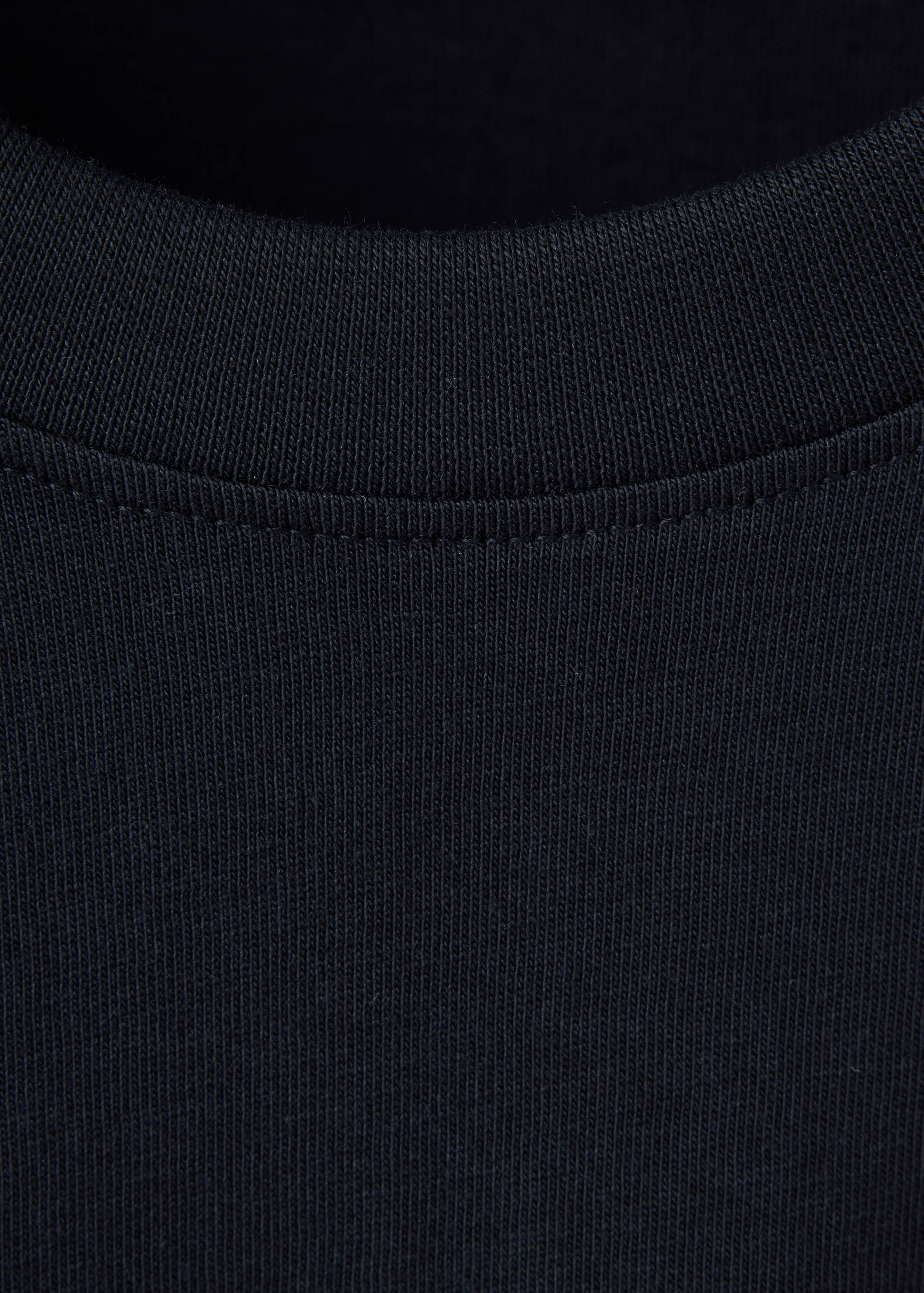 Close-up of a black t-shirt ribbed crew neckline.