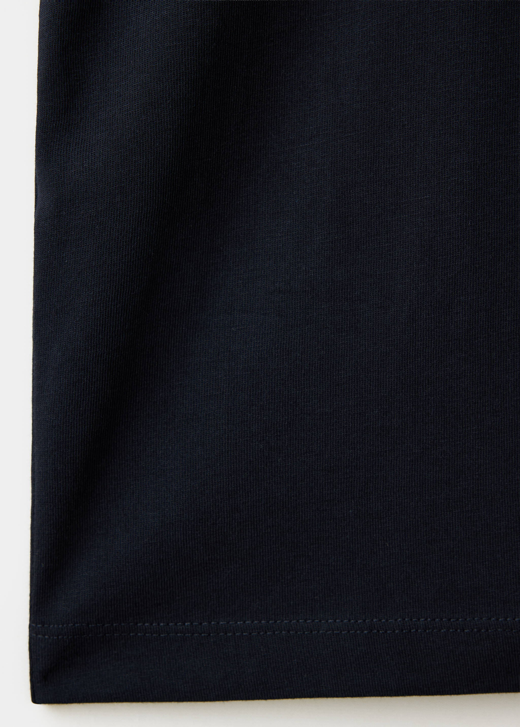 Close-up of the dark navy blue cotton fabric texture of a t-shirt.