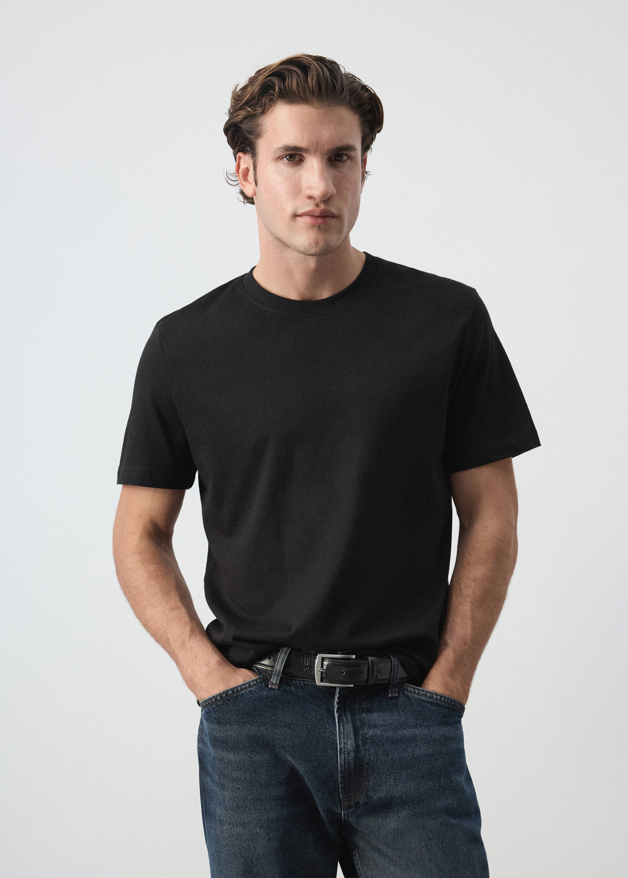 Plain black short-sleeved t-shirt with a round crew neckline worn by a model.