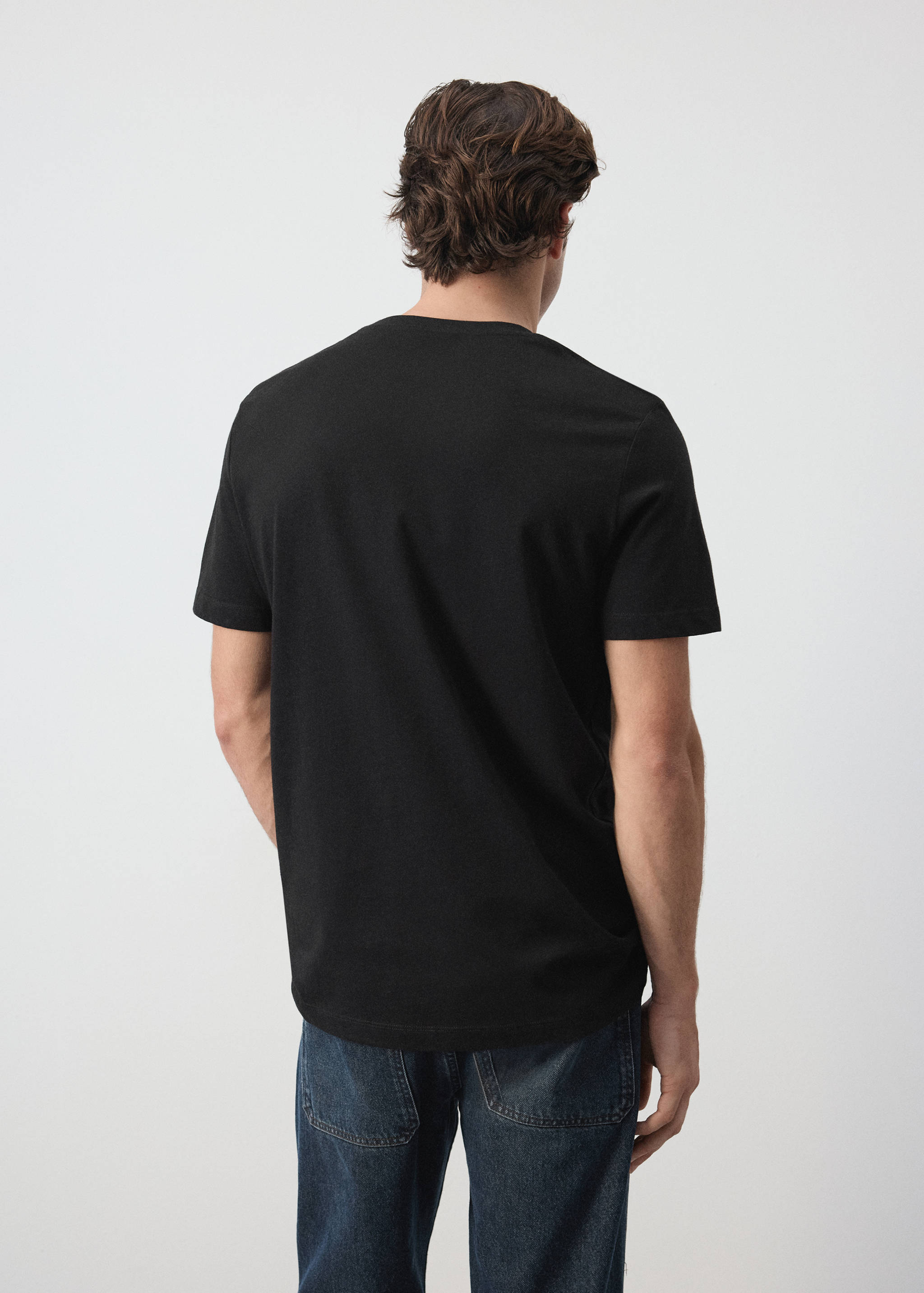 Back view of a plain black short-sleeved t-shirt on a model.