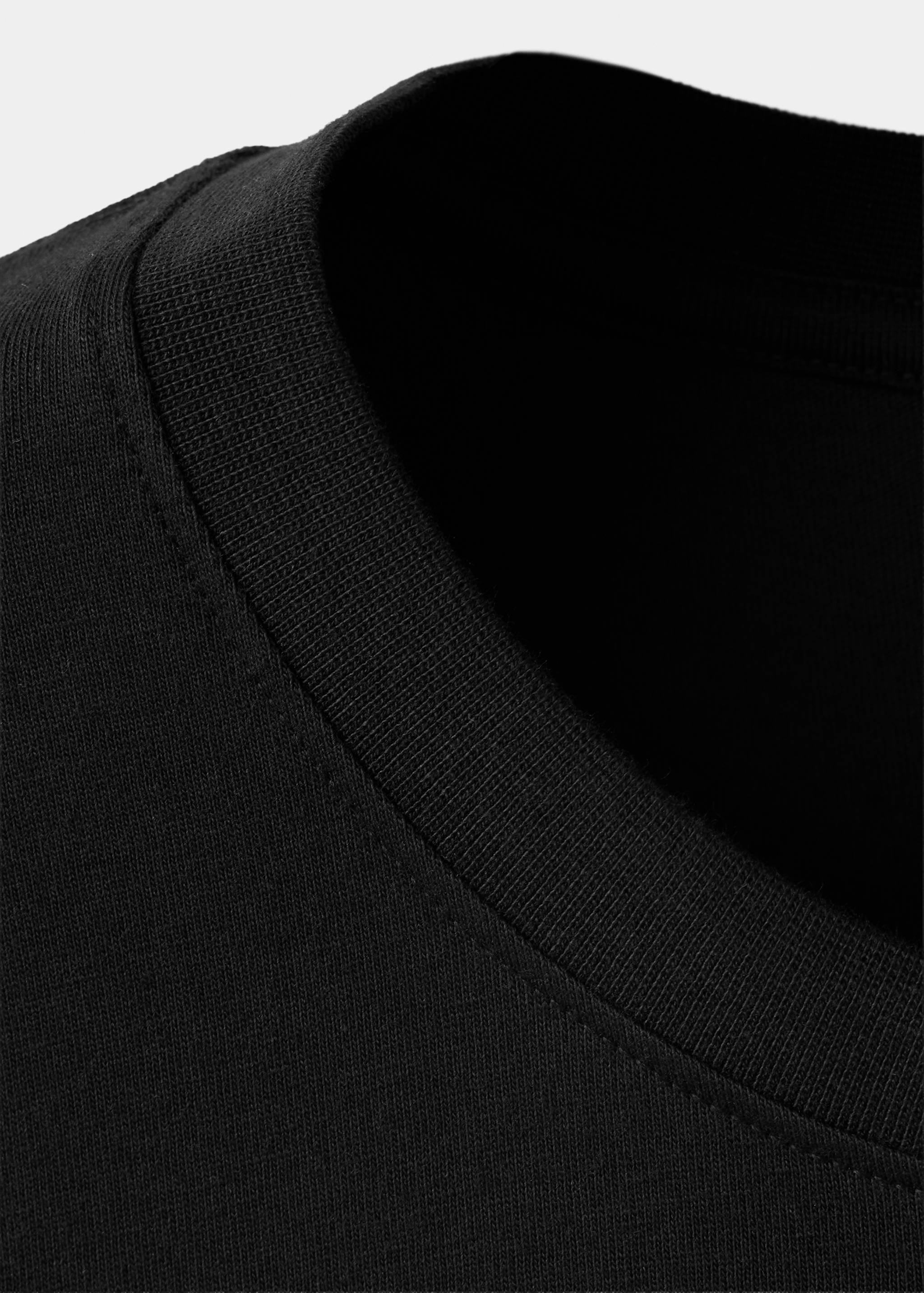 Close-up of a black t-shirt's ribbed crew neck collar.