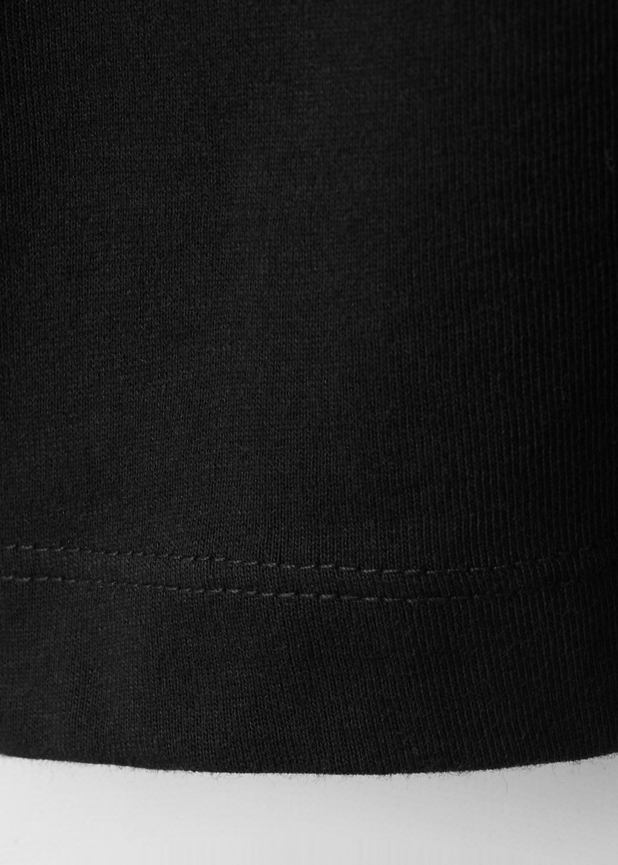 Close-up of black t-shirt fabric showing ribbed texture and hem detail.