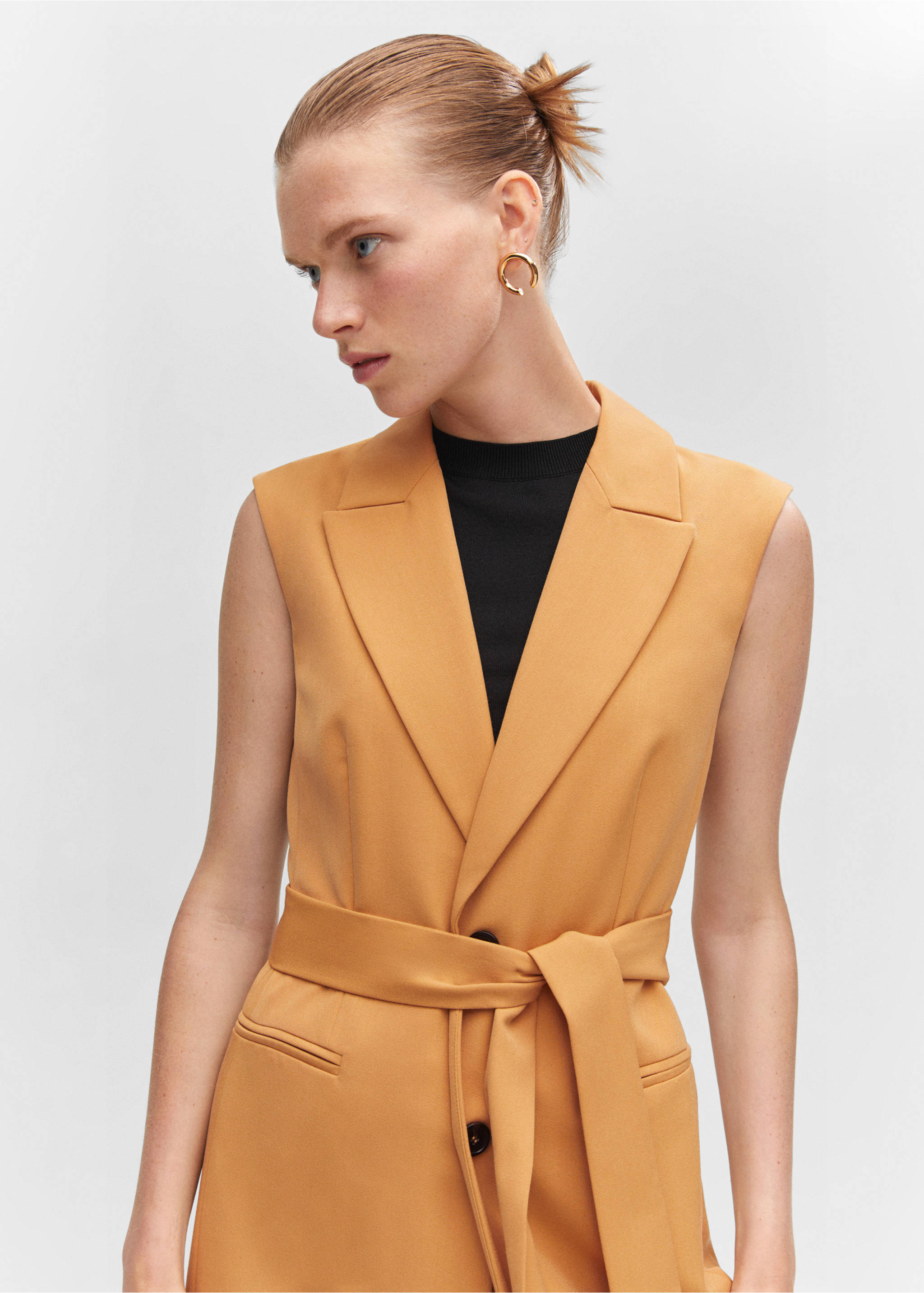 Long gilet with bow - Details of the article 1, Ochre. Ref: 57040813-00.