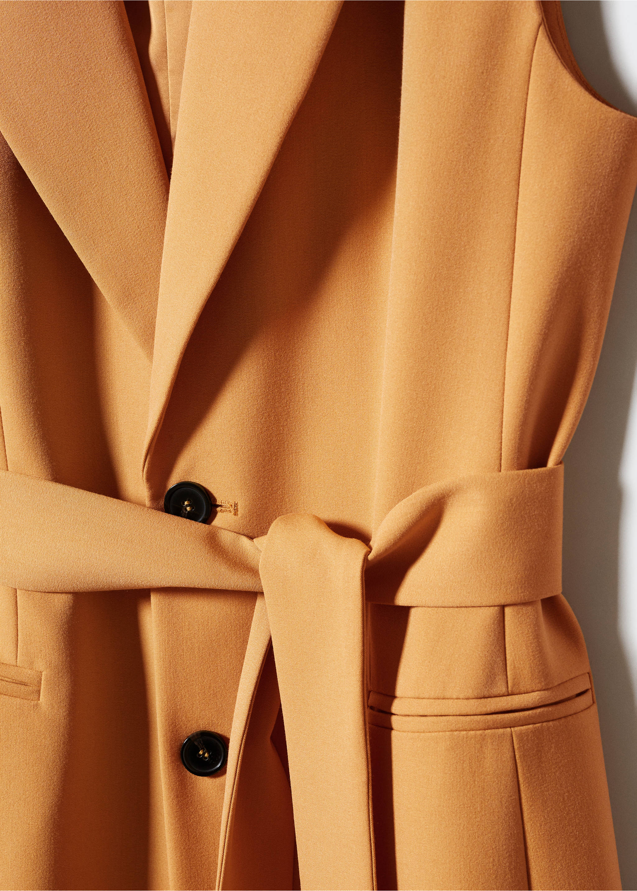 Long gilet with bow - Details of the article 8, Ochre. Ref: 57040813-00.
