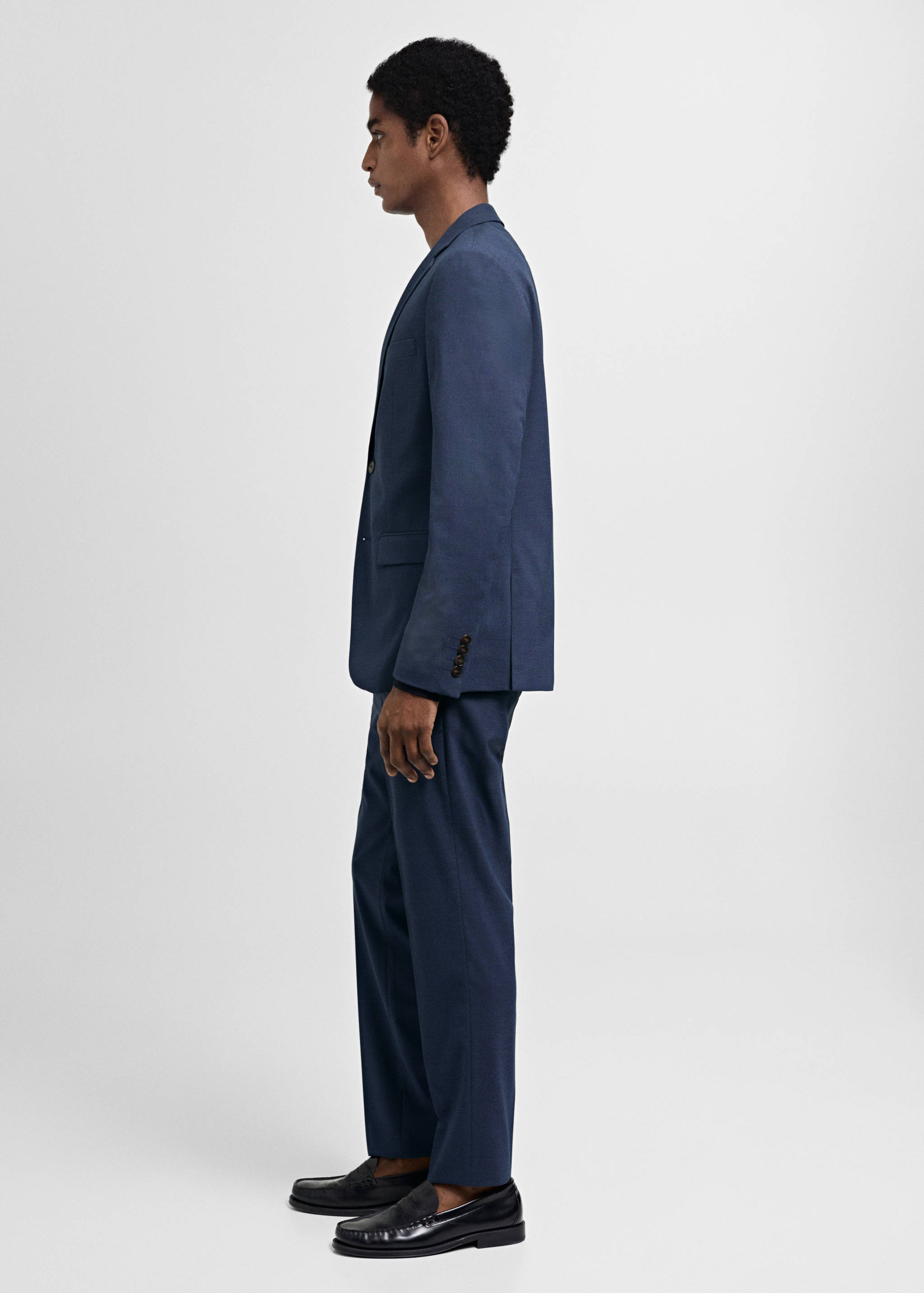 Dark blue trousers with a straight fit, worn with a matching blazer.