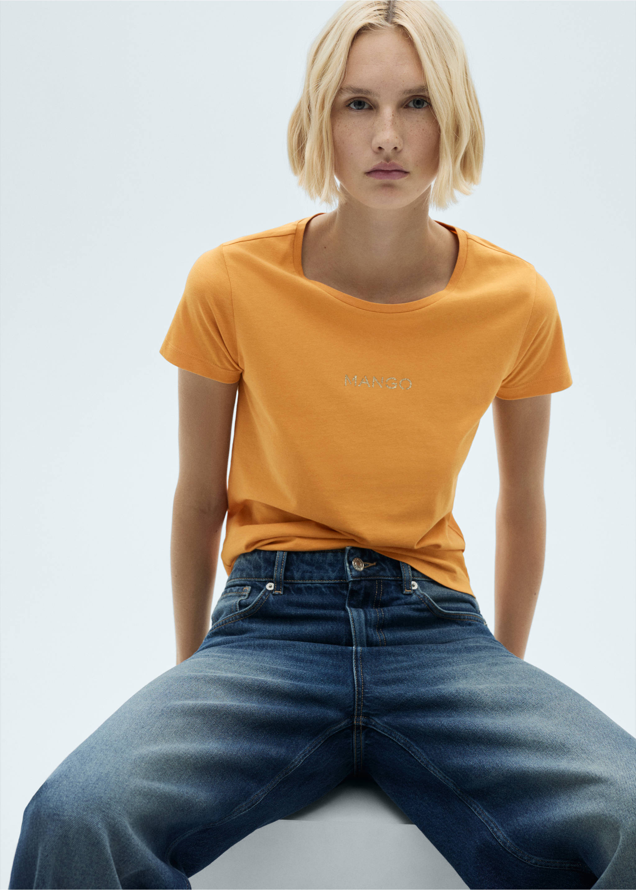 Orange short-sleeved t-shirt with a scoop neckline and a metallic logo on the chest., Mustard. Ref: 77020354-00.