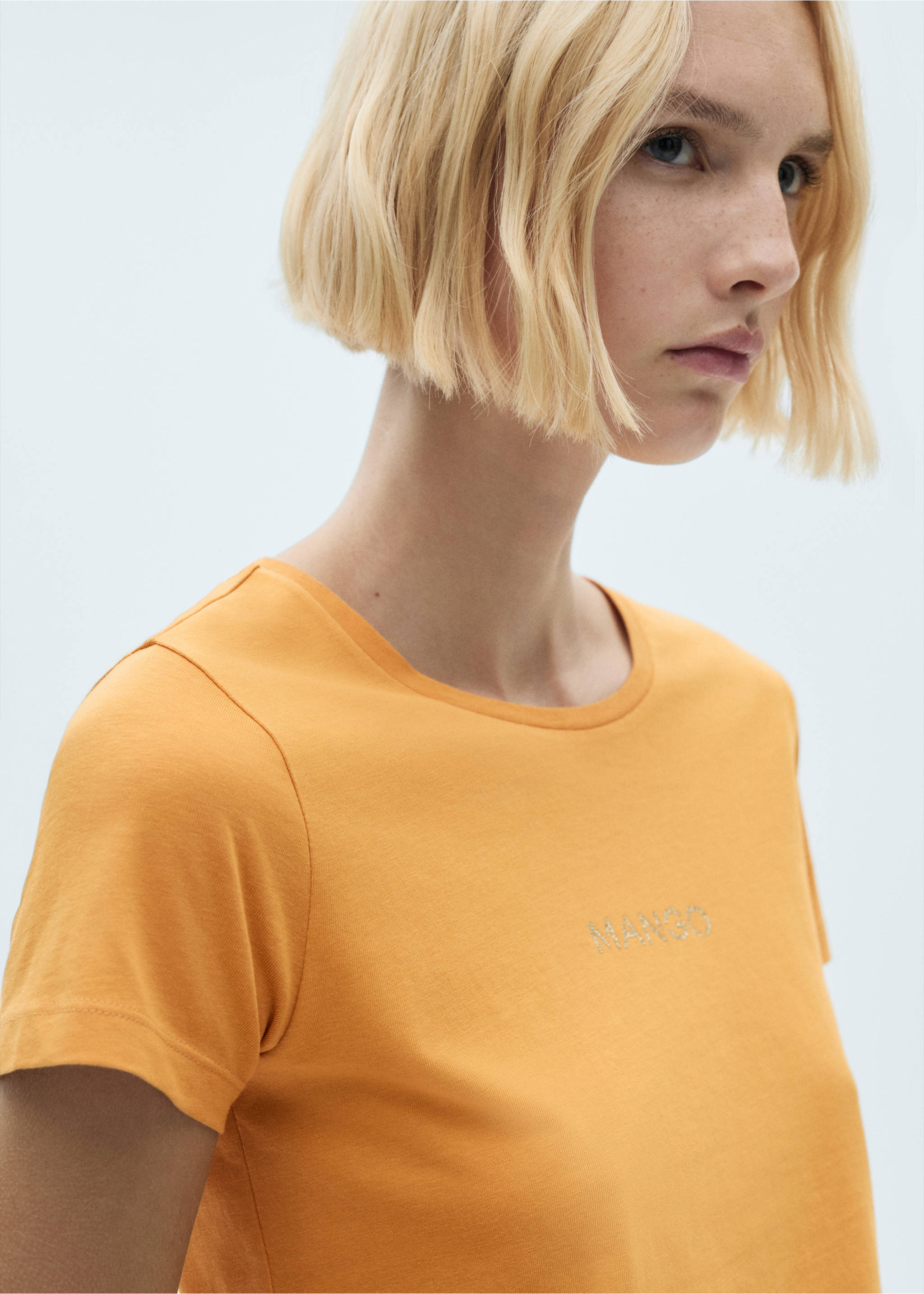 Orange short-sleeved t-shirt with a round neckline and rhinestone logo detail., Mustard. Ref: 77020354-00.