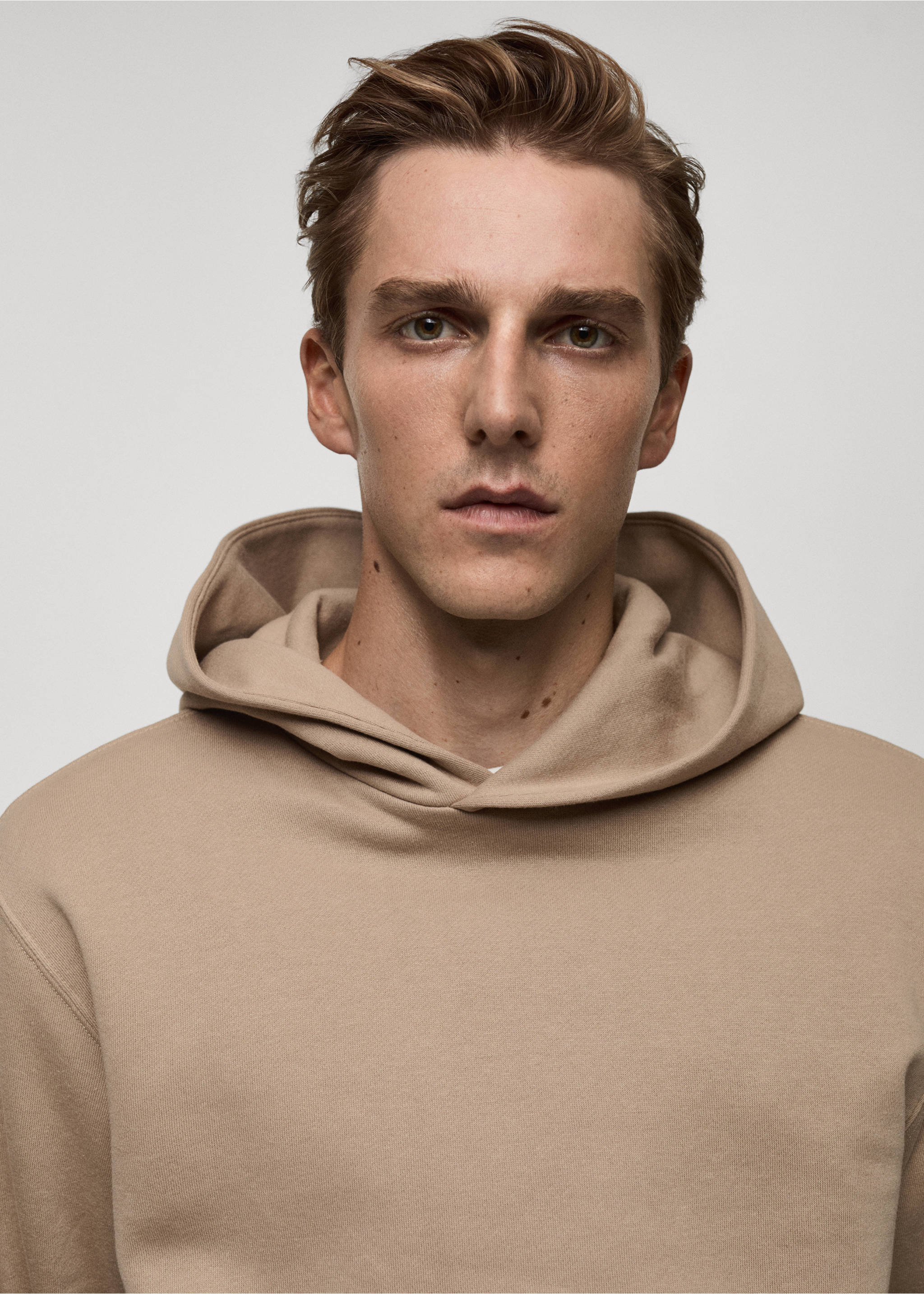 Close-up of a model wearing a beige hoodie., Medium Brown. Ref: 77027115-00.