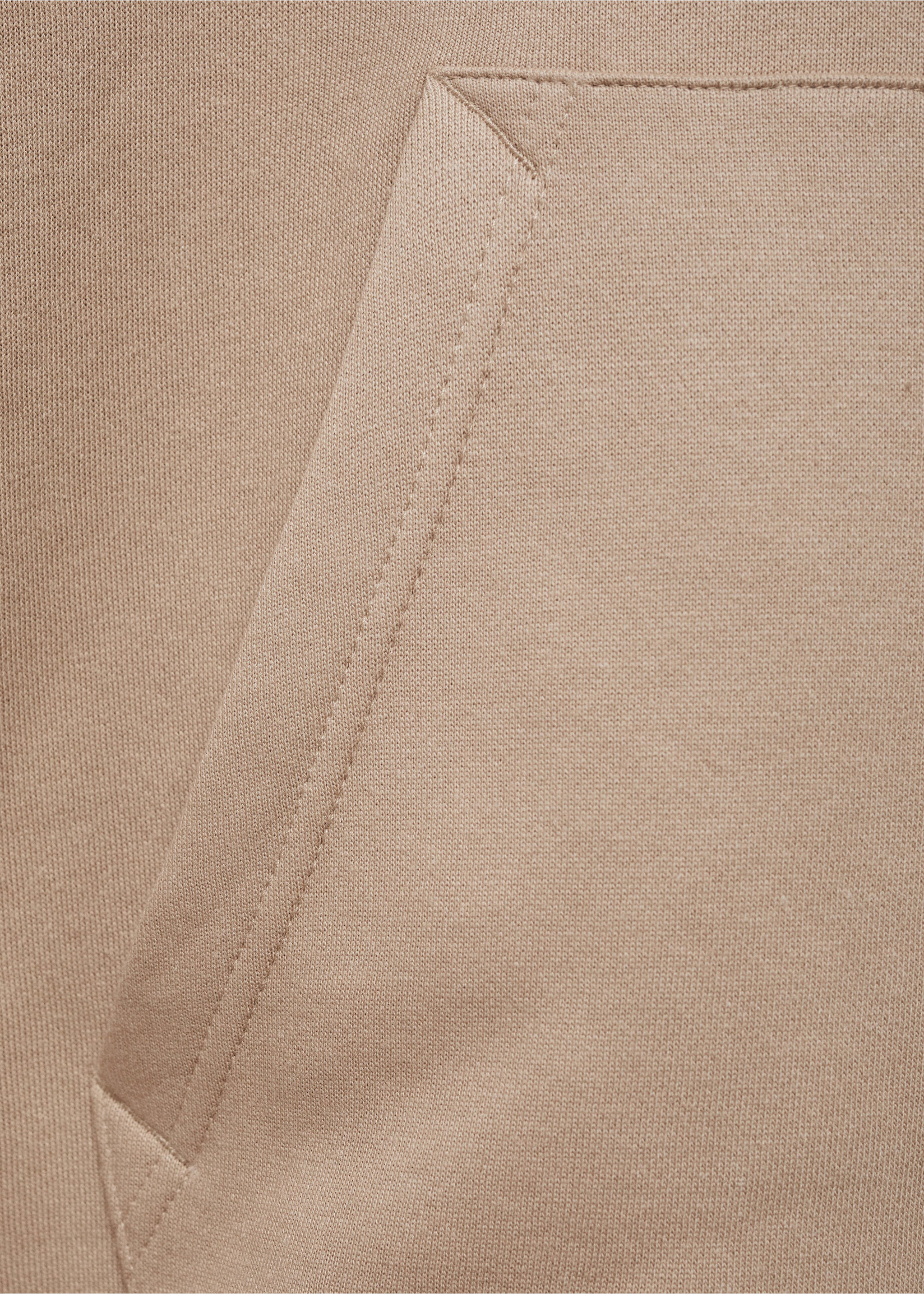Close-up of the fabric texture and pocket detail on a beige sweatshirt., Medium Brown. Ref: 77027115-00.