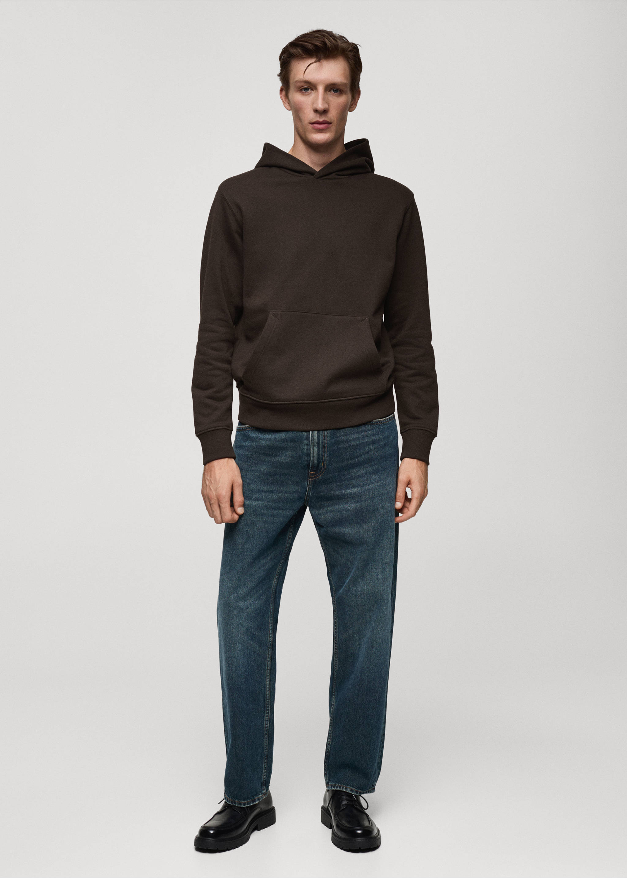 Dark brown hoodie with a kangaroo pocket worn with blue trousers., Chocolate. Ref: 77027115-00.