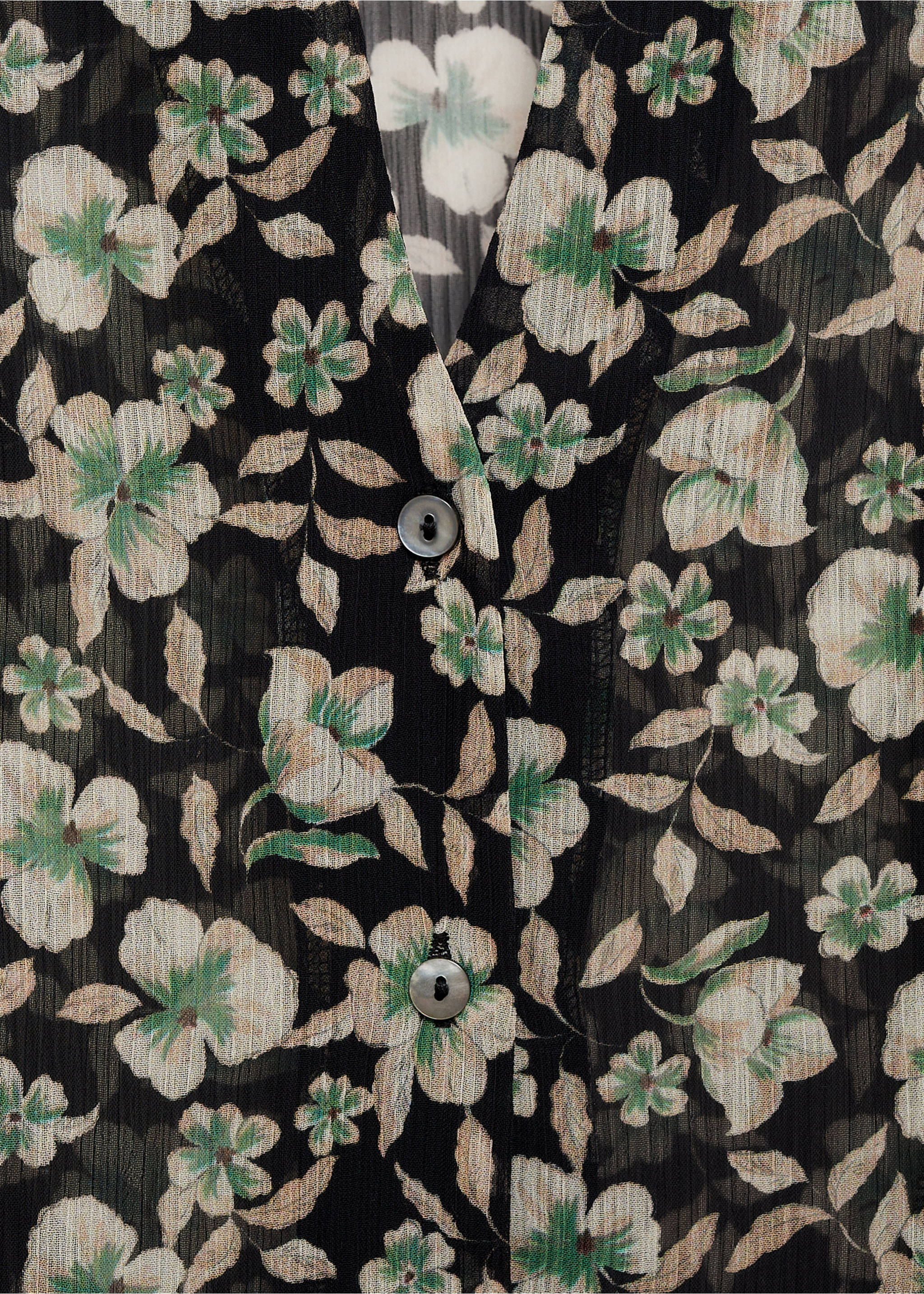 Close-up of a pleated black floral shirt with V-neckline., Black. Ref: 77027722-00.